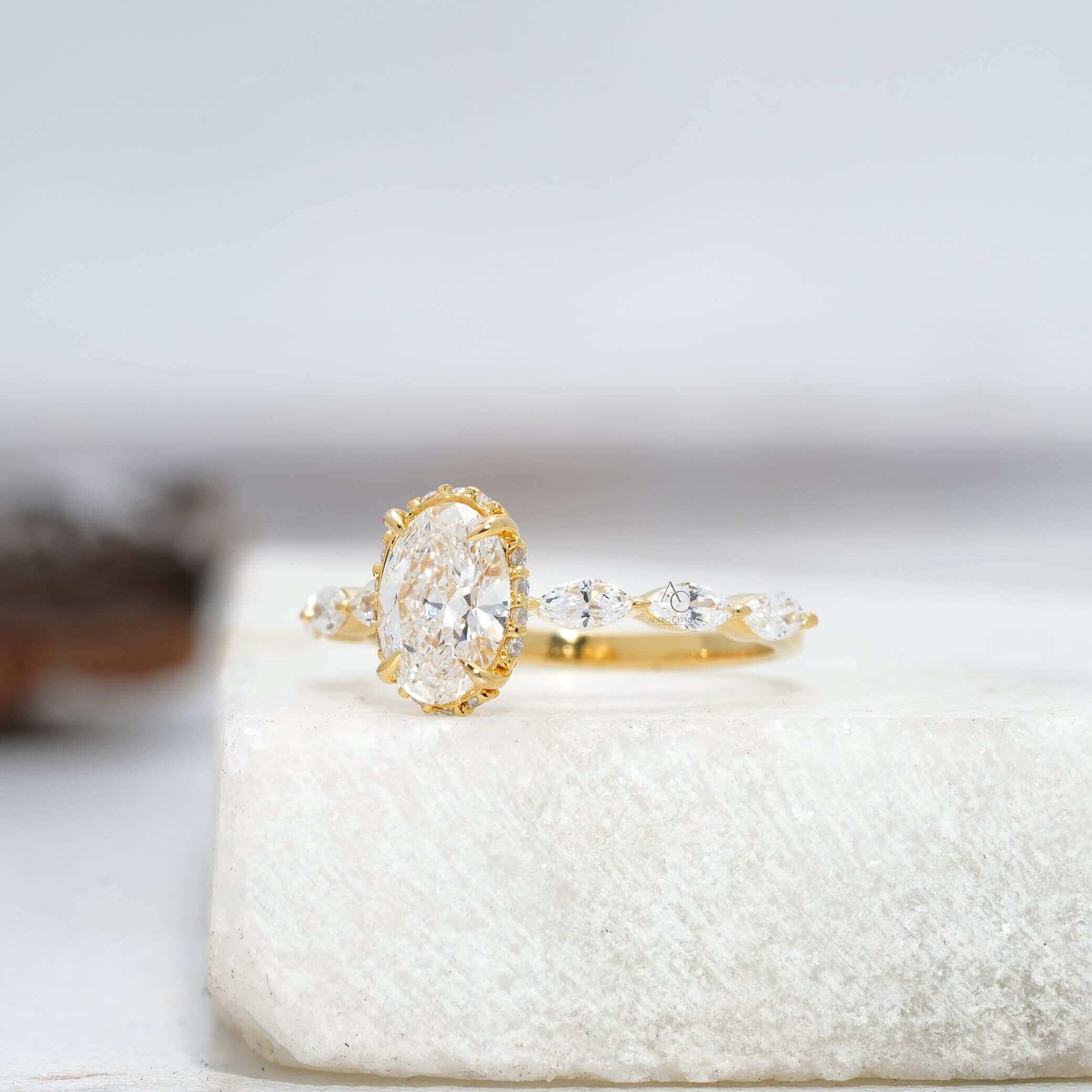 Side view of oval diamond ring with marquise accents in yellow gold.