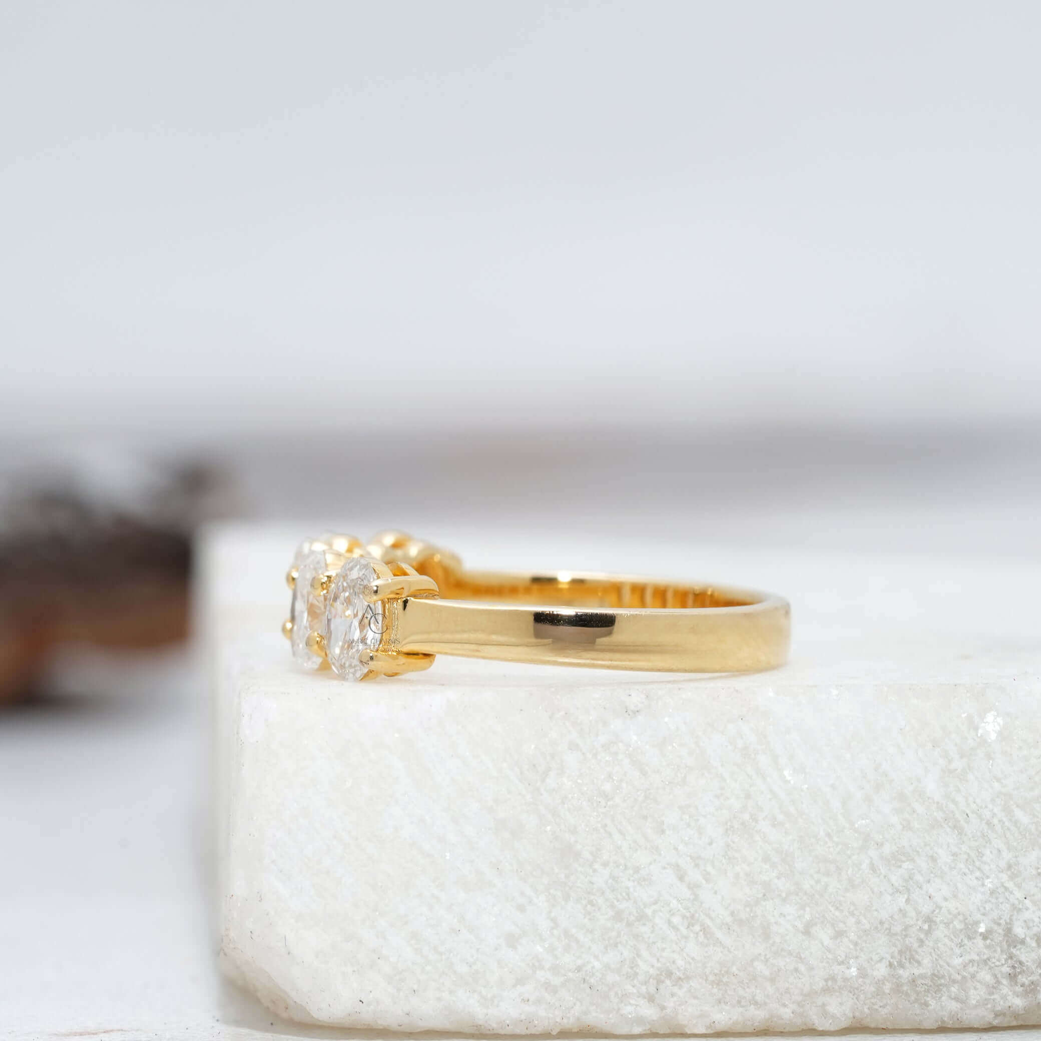 Rear view of a sleek diamond band showcasing the underside of five oval diamonds in white gold.