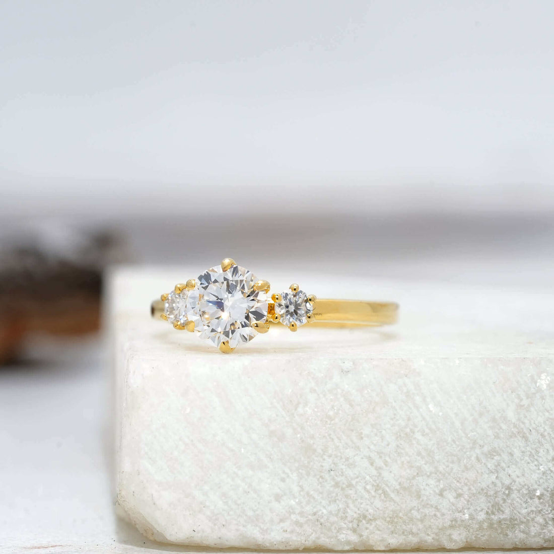 Lab-created round diamond engagement ring featuring three-stone design.