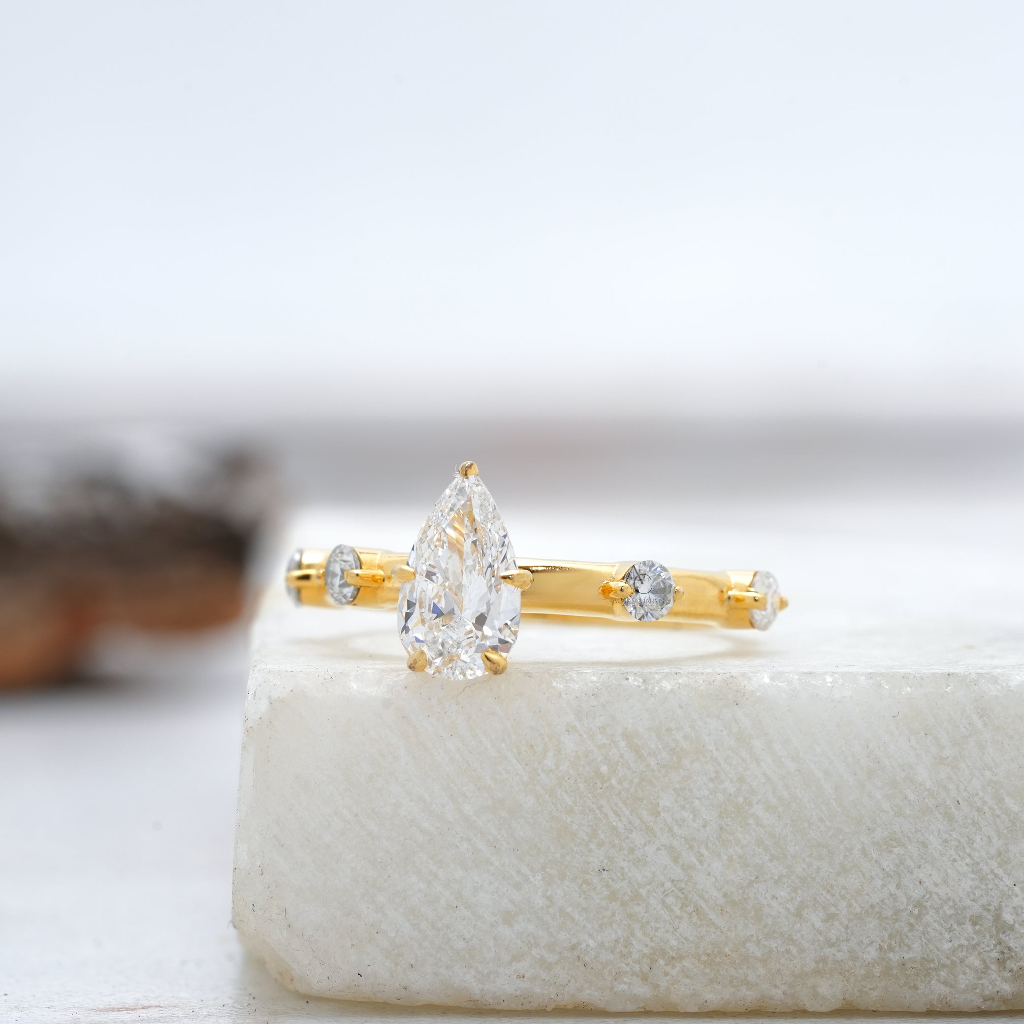 Side view of a pear-cut diamond ring with intricate accents, highlighting the brilliance of lab-grown diamonds.