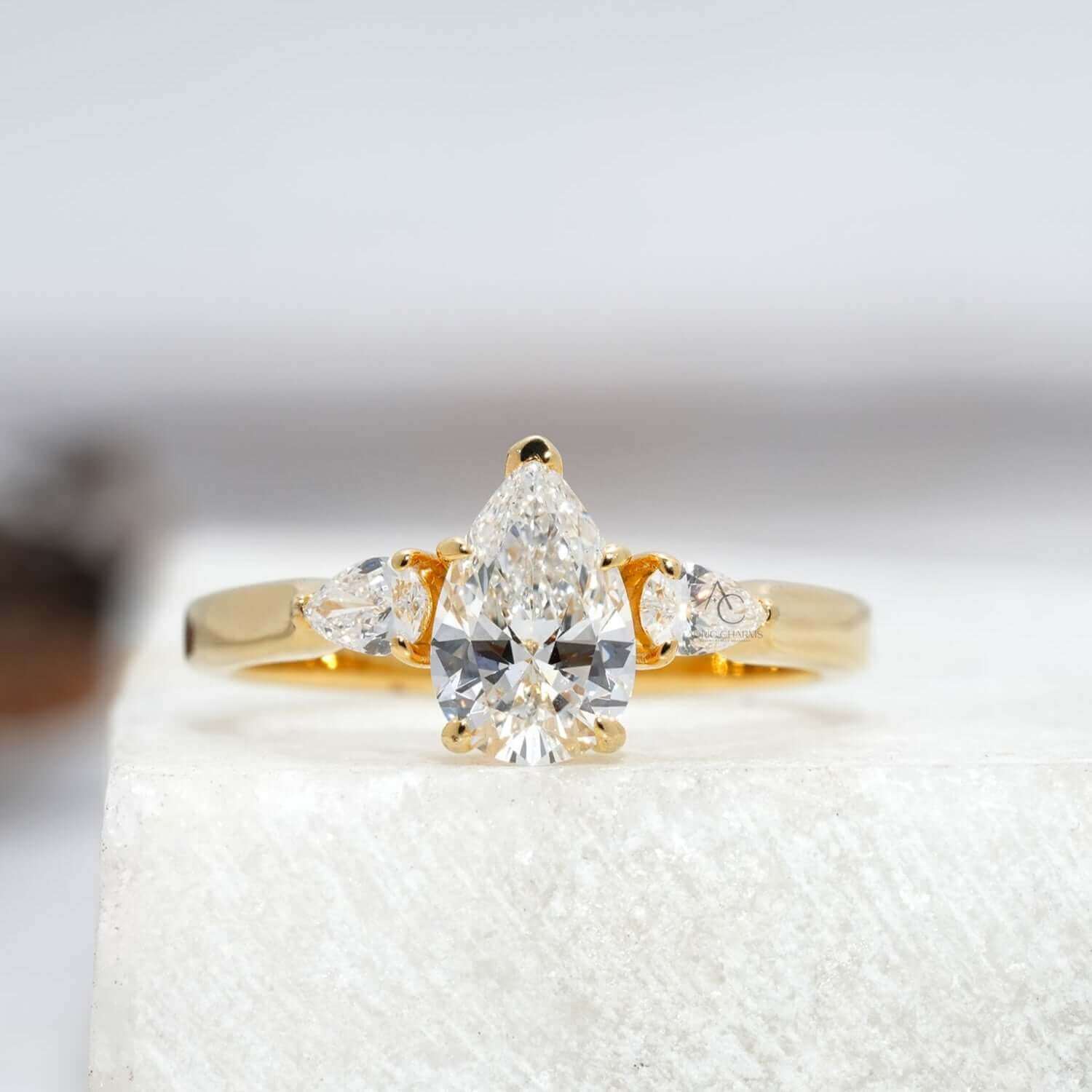 Exquisite pear-cut diamond engagement ring with a reflective platinum band, elegant design.