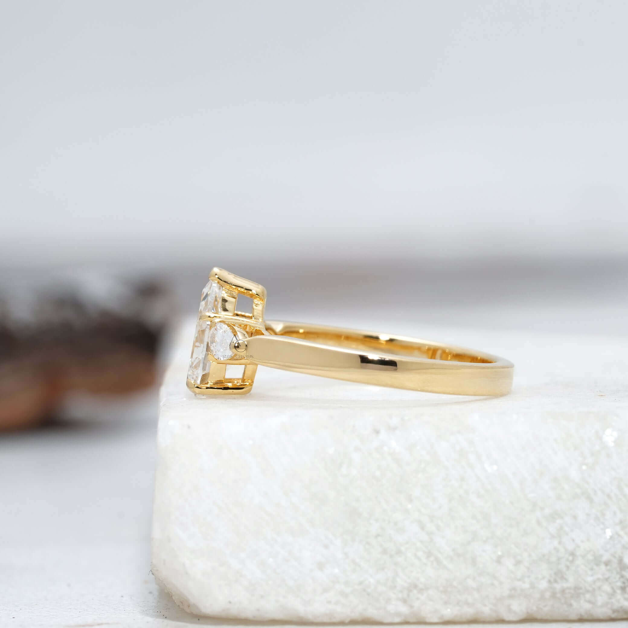 Side view of a pear-cut diamond ring, highlighting the delicate setting and reflective design.