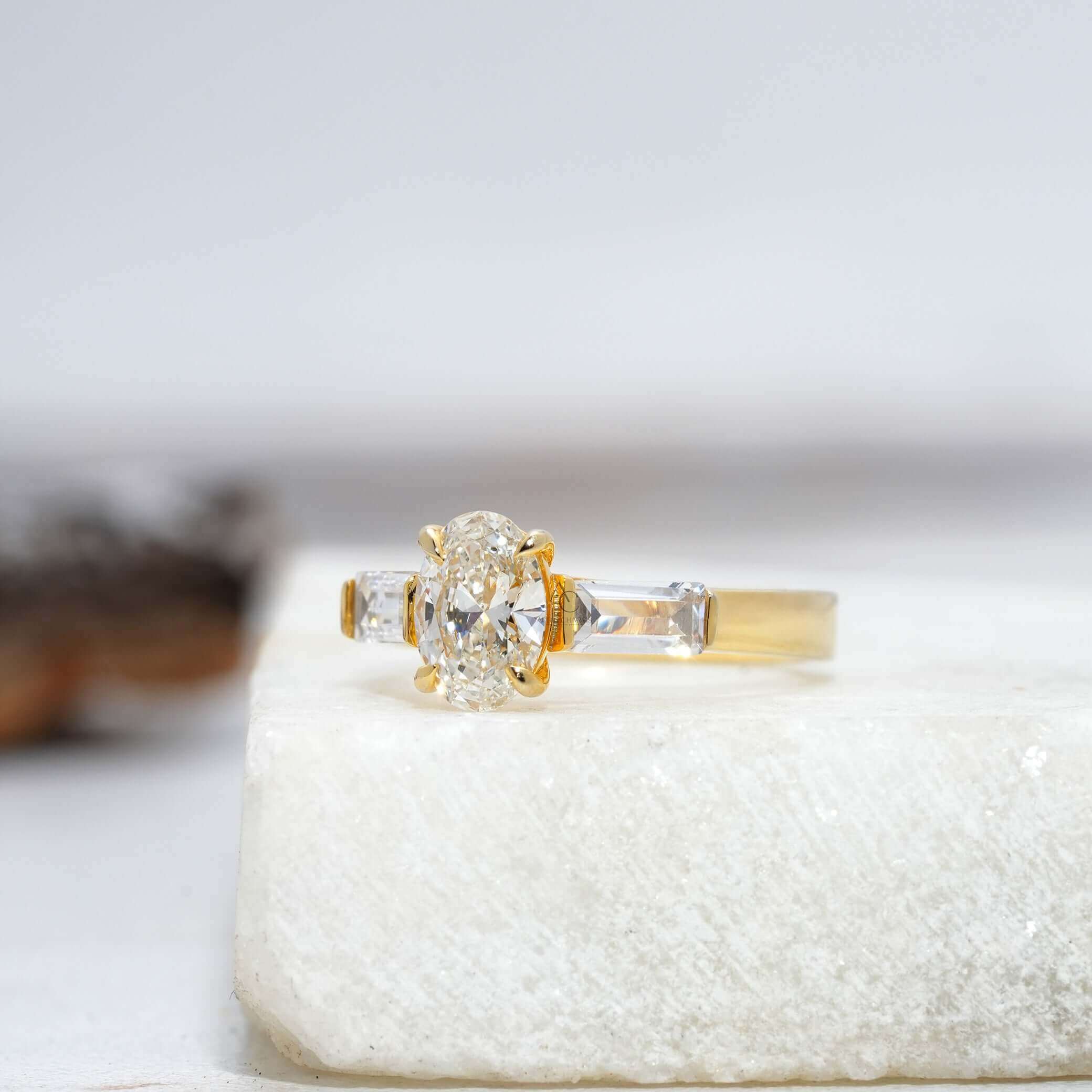 Side view of a classic oval diamond ring with baguettes, reflecting sleek luxury and sparkle.