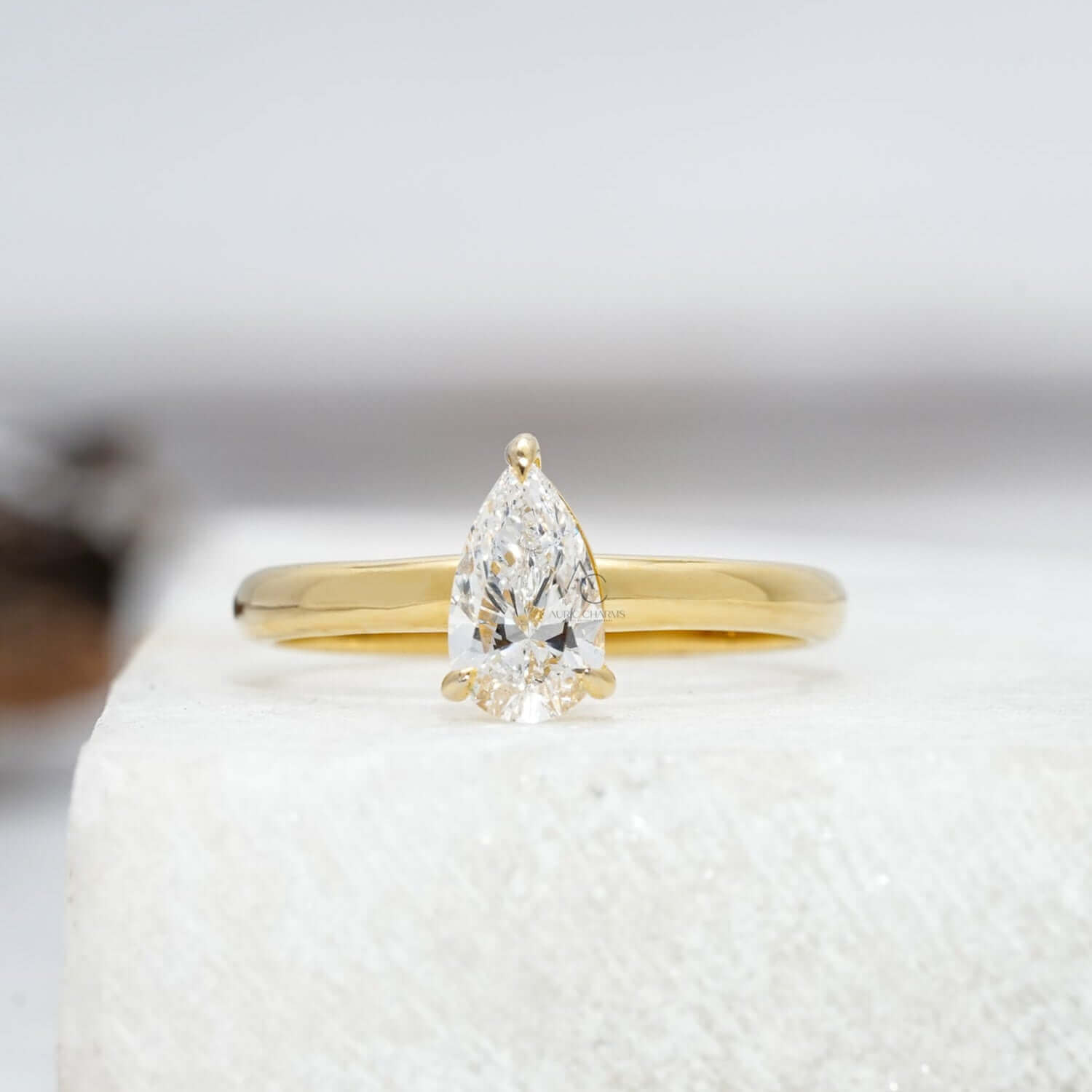 A timeless pear-cut lab-grown diamond solitaire ring featuring a sleek, polished platinum band, capturing its elegance and brilliance in a reflective white background
