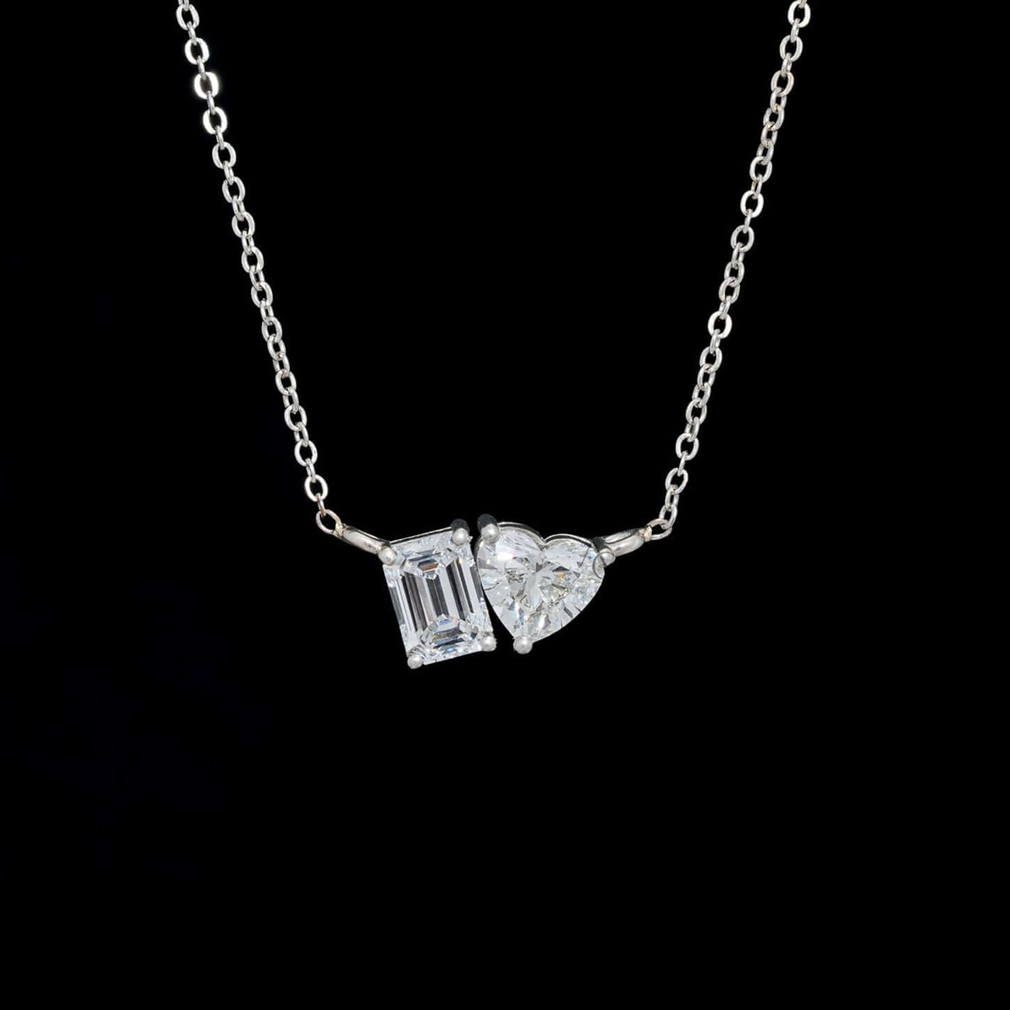 Elegant Toi et Moi pendant featuring a lab-grown emerald cut and heart diamond, perfect for an ethical engagement gift, worn on neck.