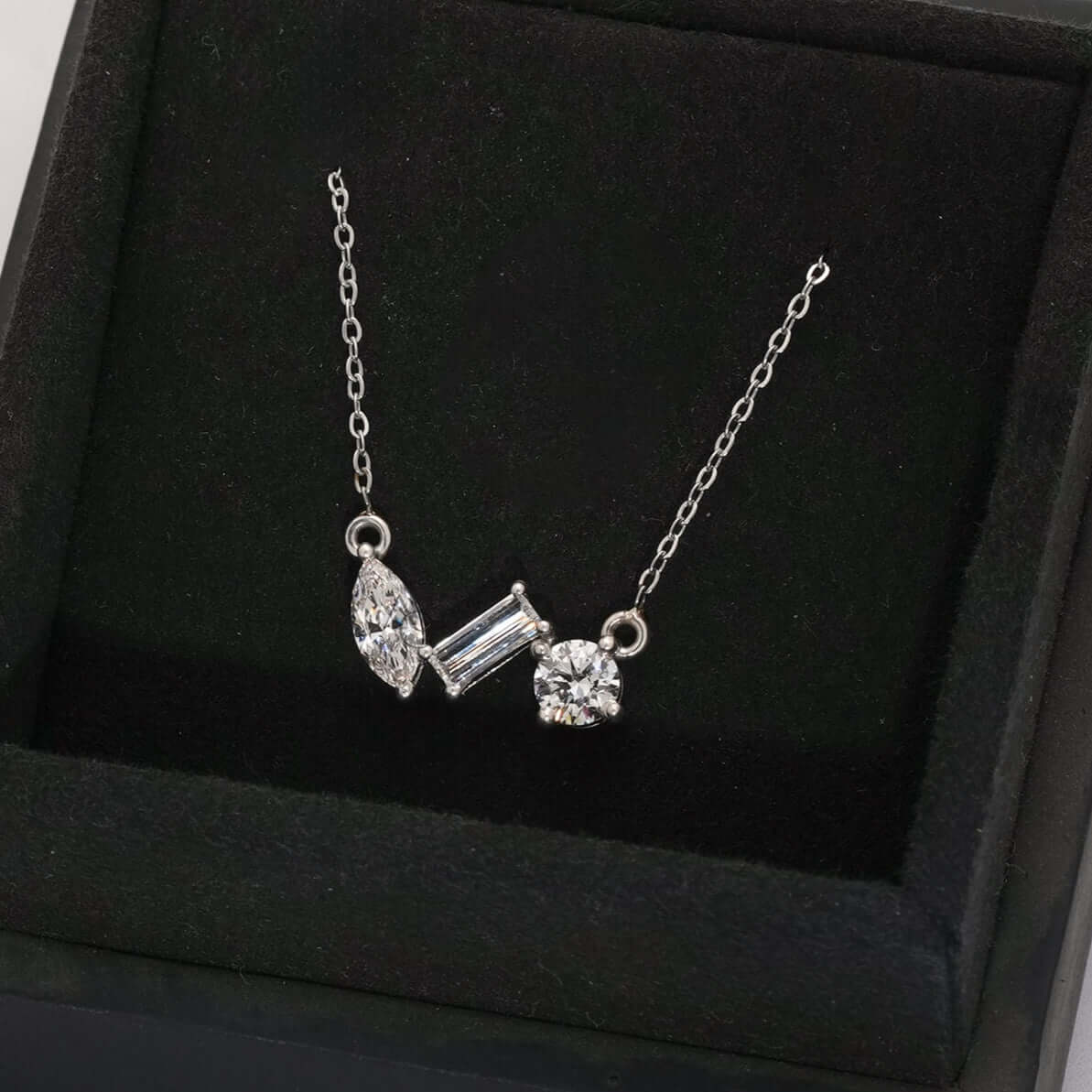 A stunning lab-grown diamond trio pendant necklace featuring a Round, Marquise, and Baguette cut, worn elegantly on a chain.