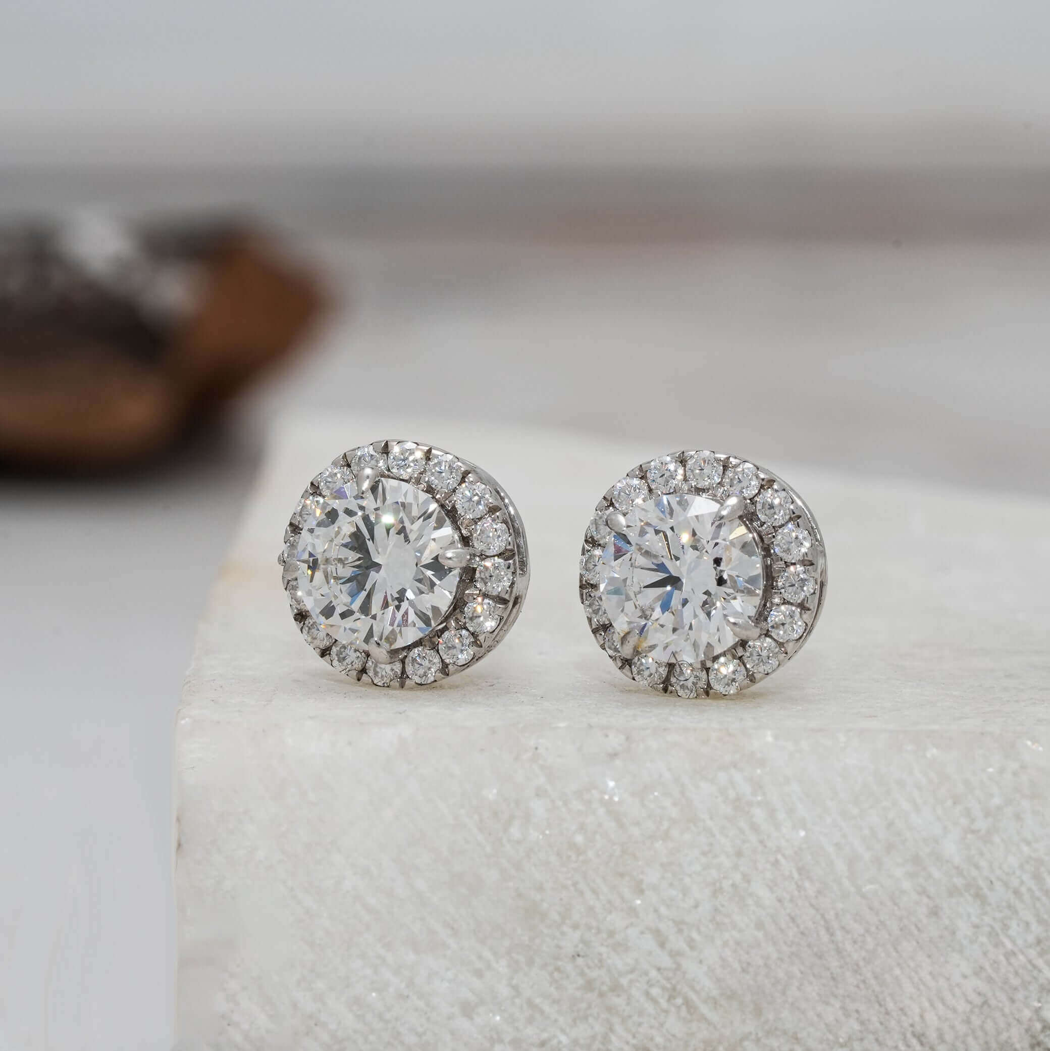 Side angle of round diamond halo earrings highlighting the diamond sparkle.