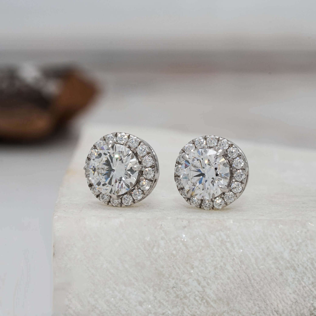 Side angle of round diamond halo earrings highlighting the diamond sparkle.