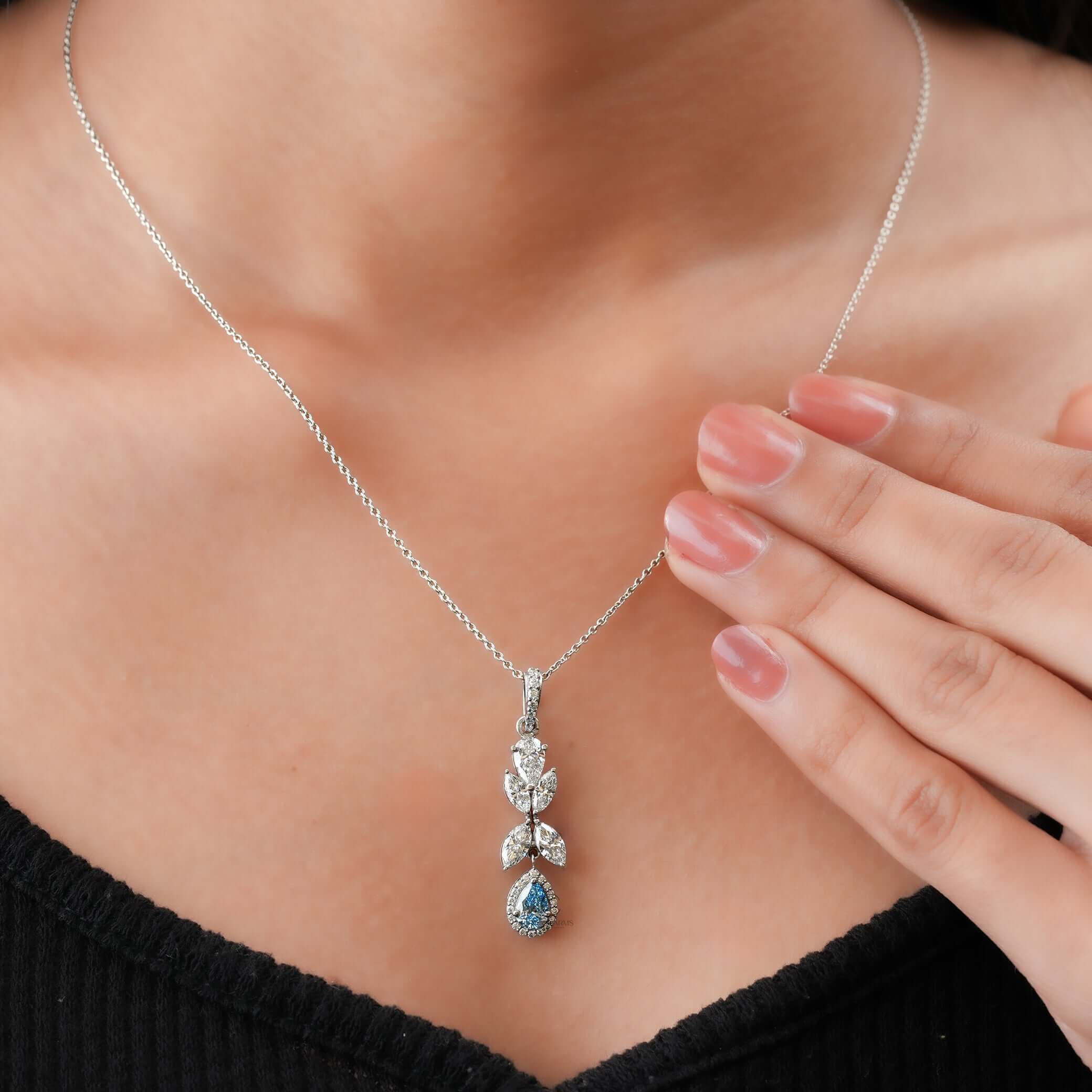 Detail view of white gold pendant necklace with marquise and pear-cut lab-grown diamonds and blue