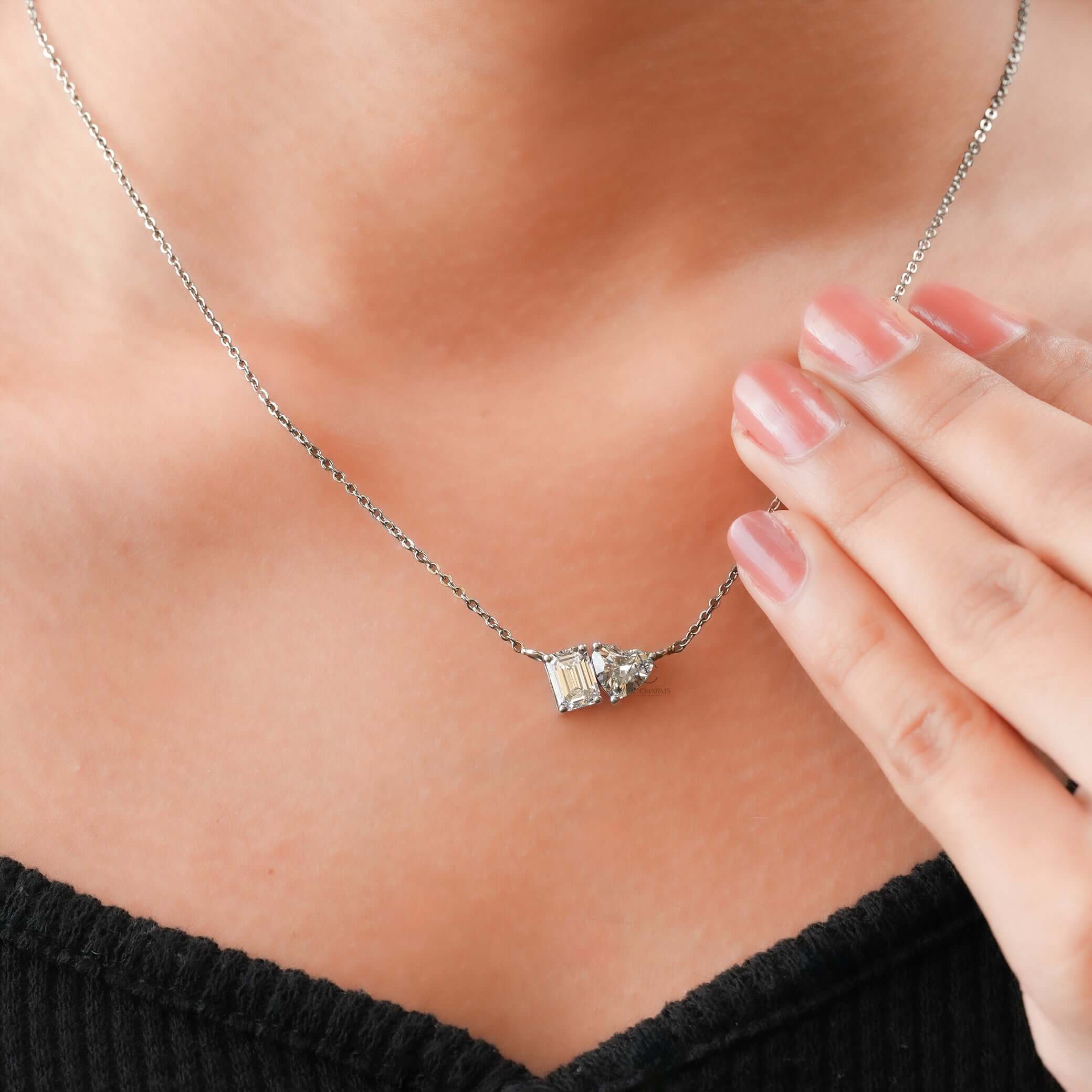 A luxurious Toi et Moi pendant featuring lab-grown diamonds, worn on the neck, showcasing an Emerald and Heart cut design.