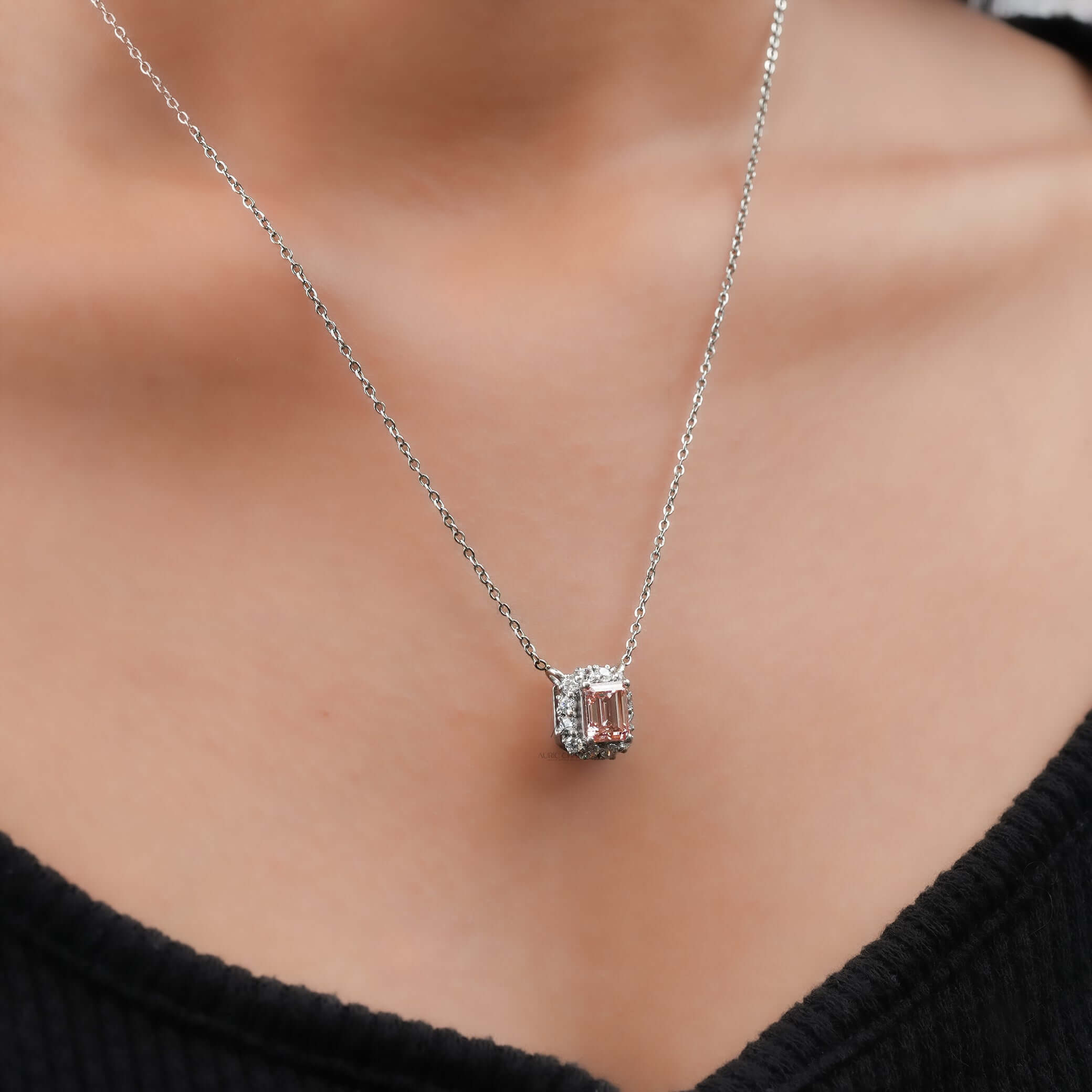 Fancy pink emerald cut lab grown diamond halo pendant necklace worn on neck, radiating luxury and timeless elegance.