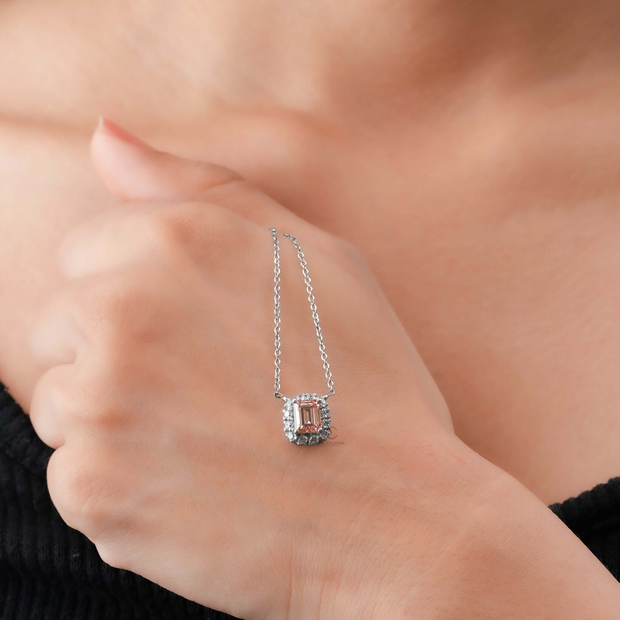 A luxurious Fancy Pink Emerald Cut Lab Grown Diamond Halo Pendant necklace, elegantly worn on hand, showcasing its exquisite sparkle.