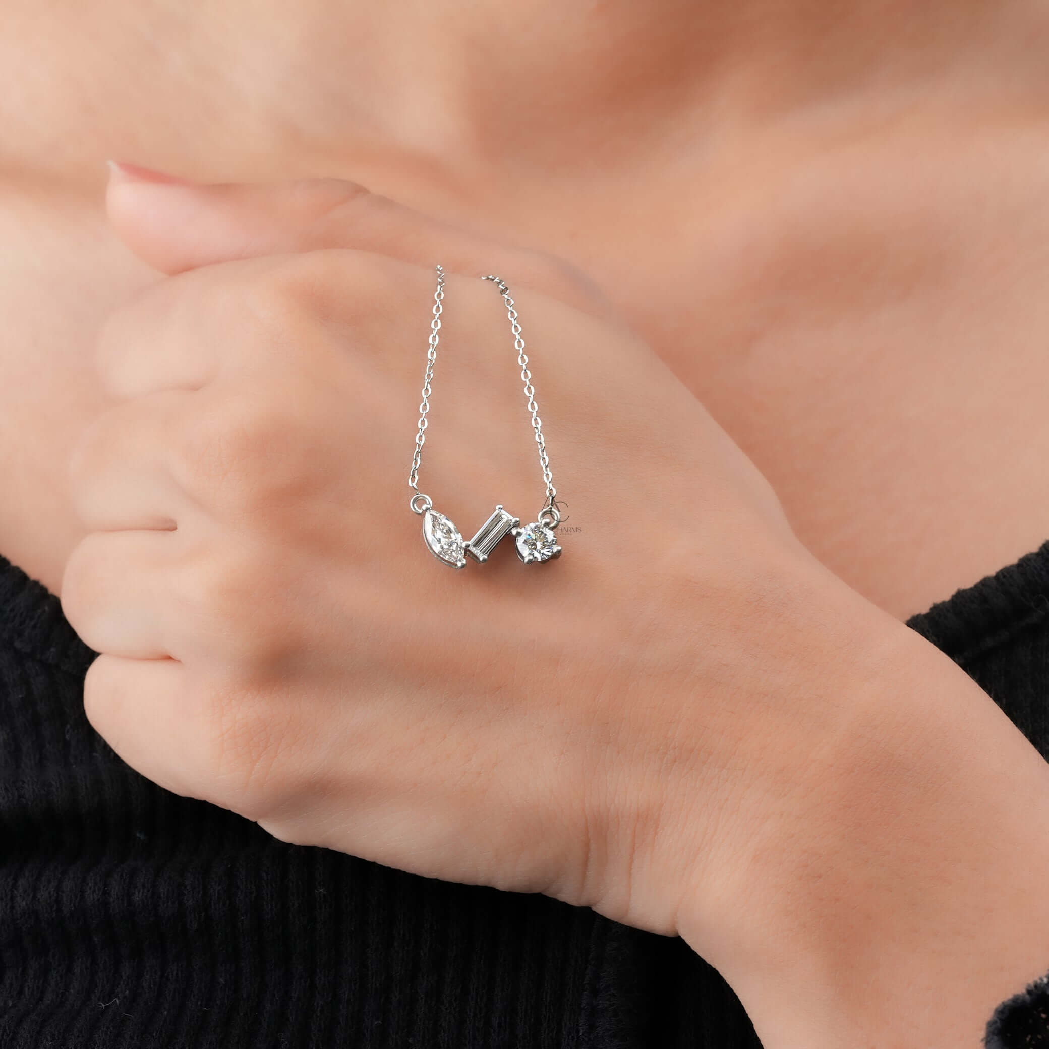 Worn on hand, this sustainable jewelry features a stunning trio of lab-grown diamonds in round, marquise, and baguette cuts.