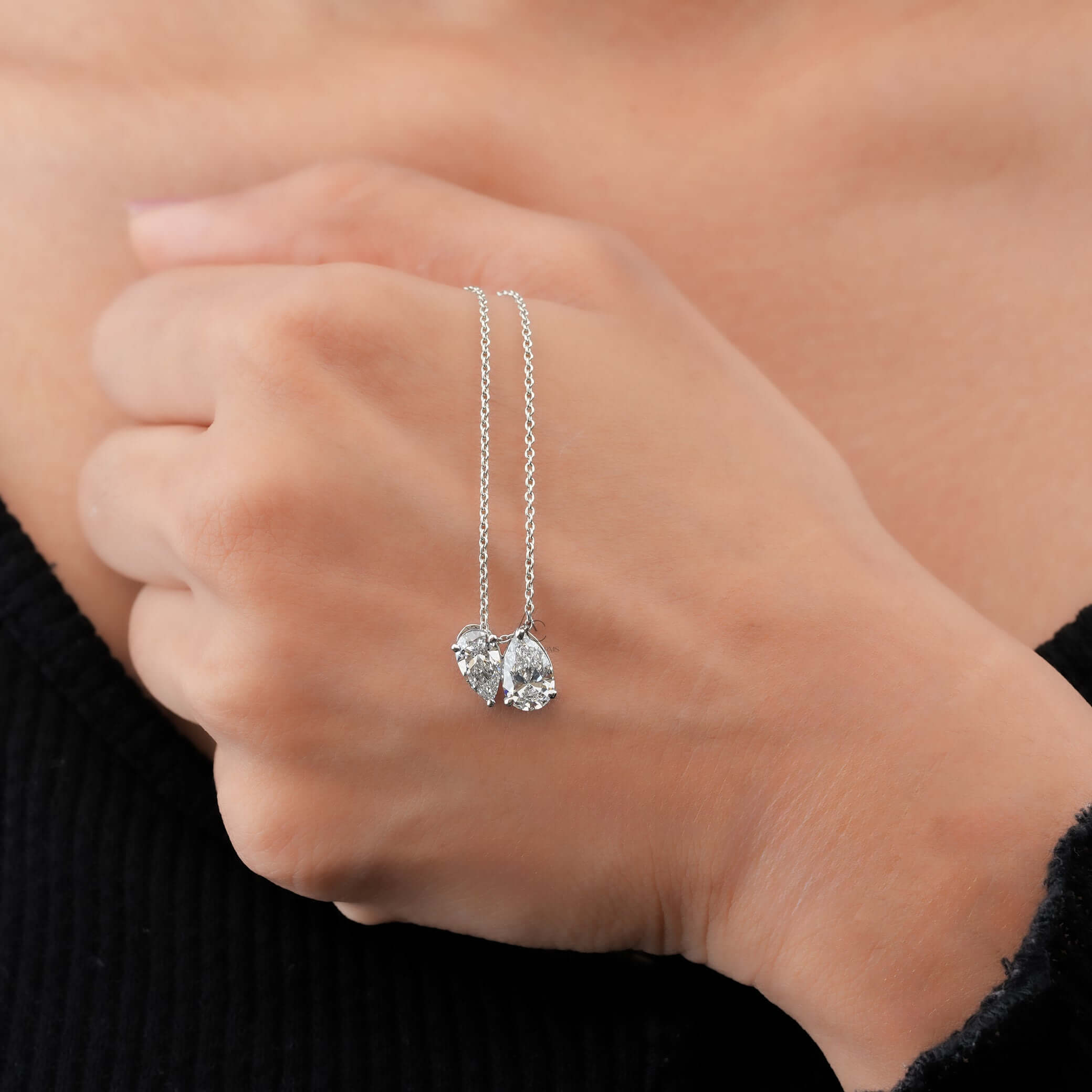 Toi et Moi pendant with pear cut lab grown diamonds elegantly shown with hand, symbolizing luxury and emotional gifting.