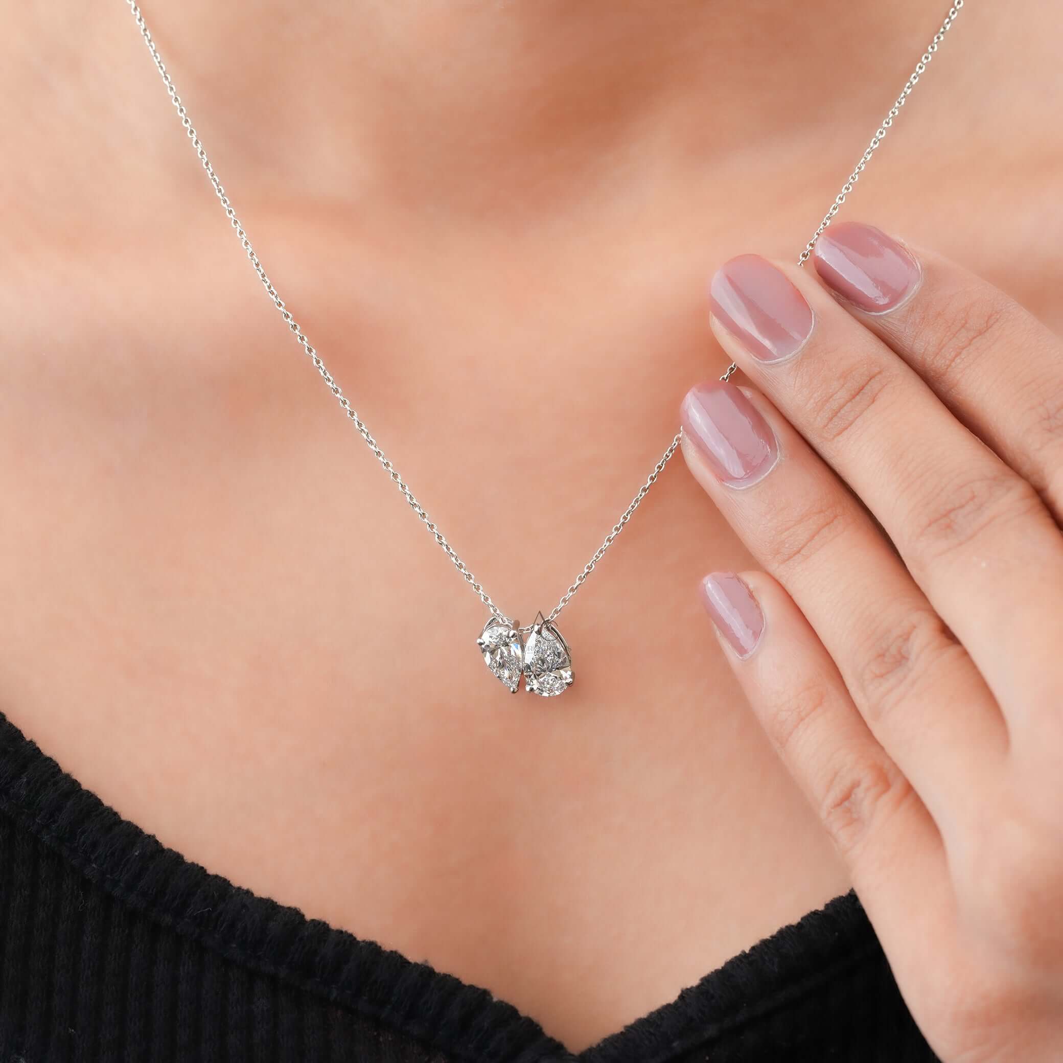 A Toi et Moi pendant necklace with two Pear-cut lab-grown diamonds, elegantly worn on the neck, showcasing luxury and sustainability.