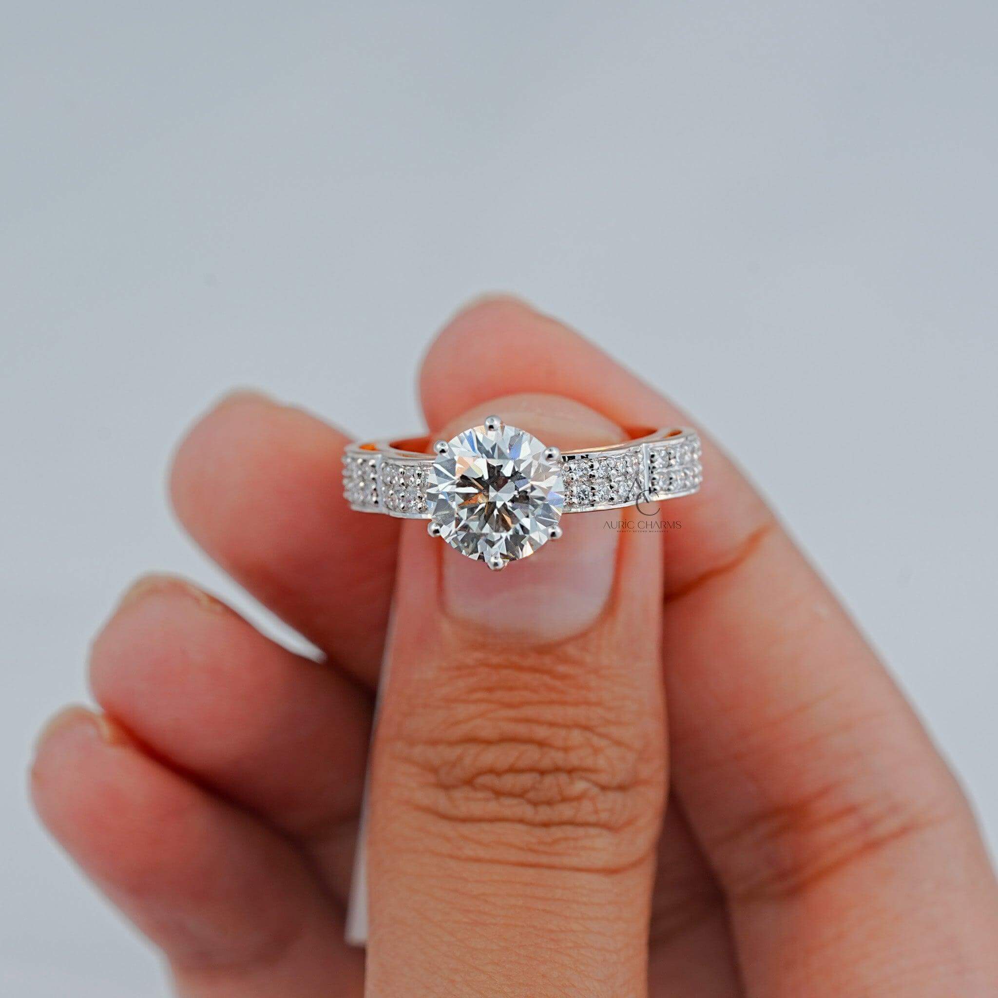 Close-up of a round diamond ring with intricate side stones.