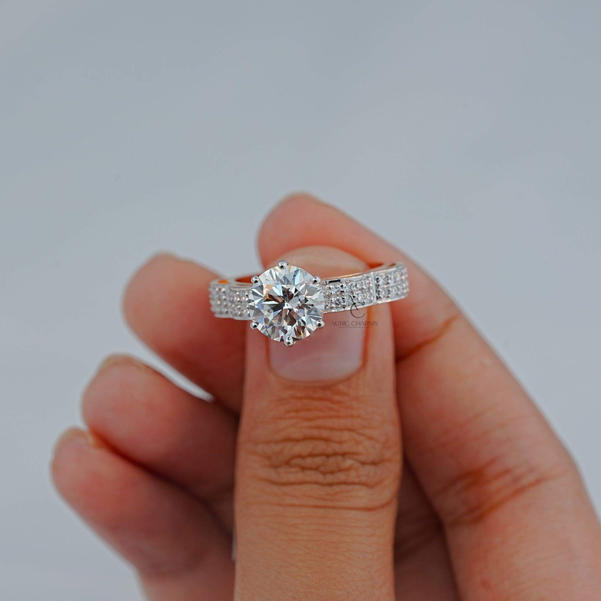 Detailed view of a diamond ring held between fingers.