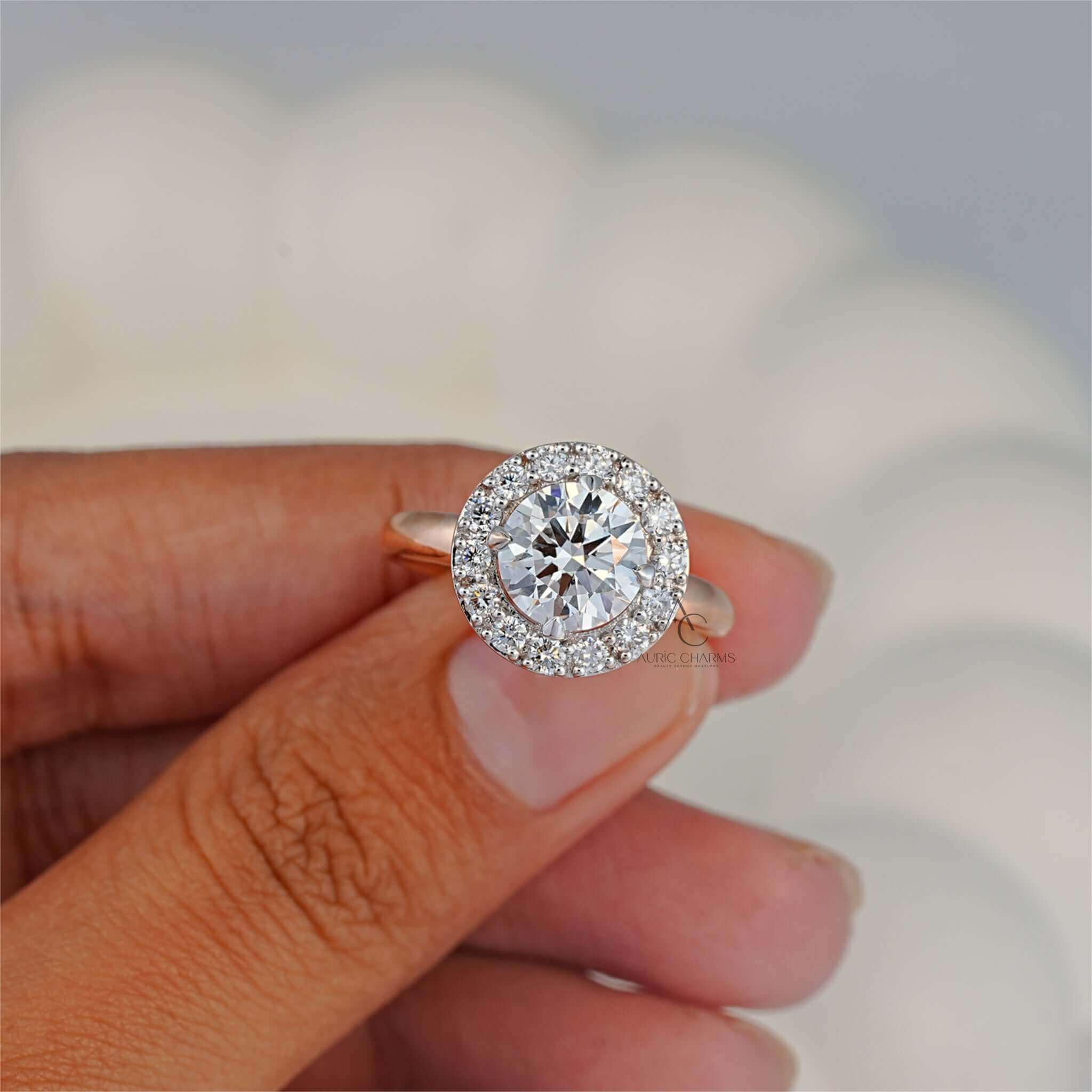 Close-up of double halo diamond ring with round center stone held between fingers.