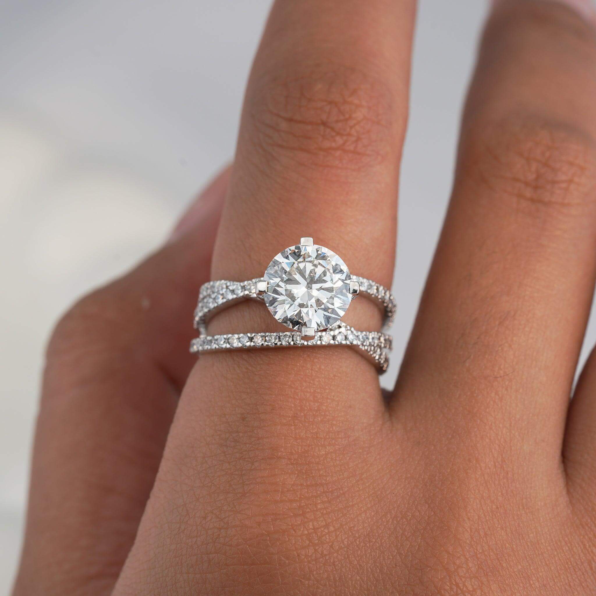 Round brilliant-cut diamond solitaire ring with a double pave band, elegant and timeless design.