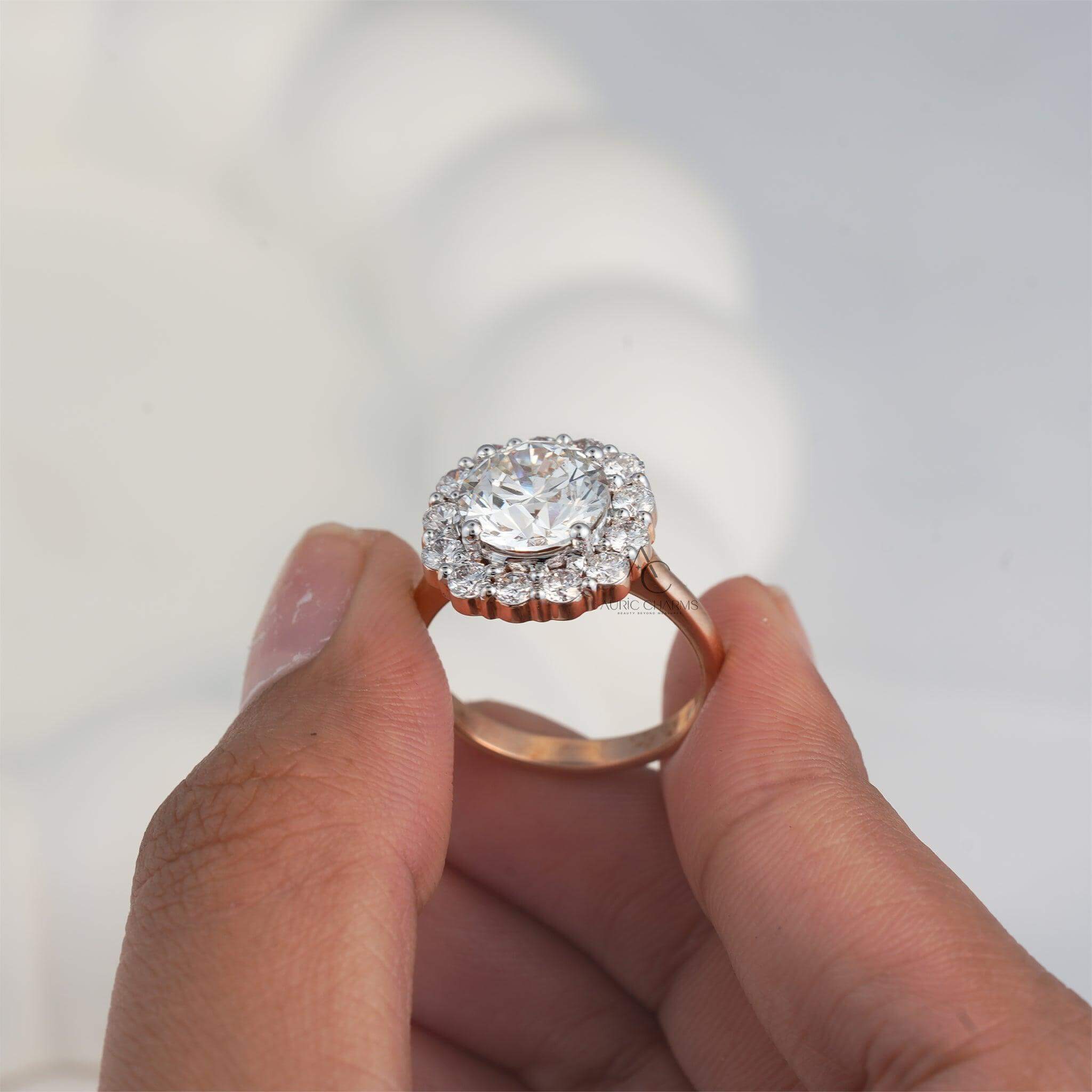 Close-up of a round halo diamond ring with accent stones in a rose gold band.