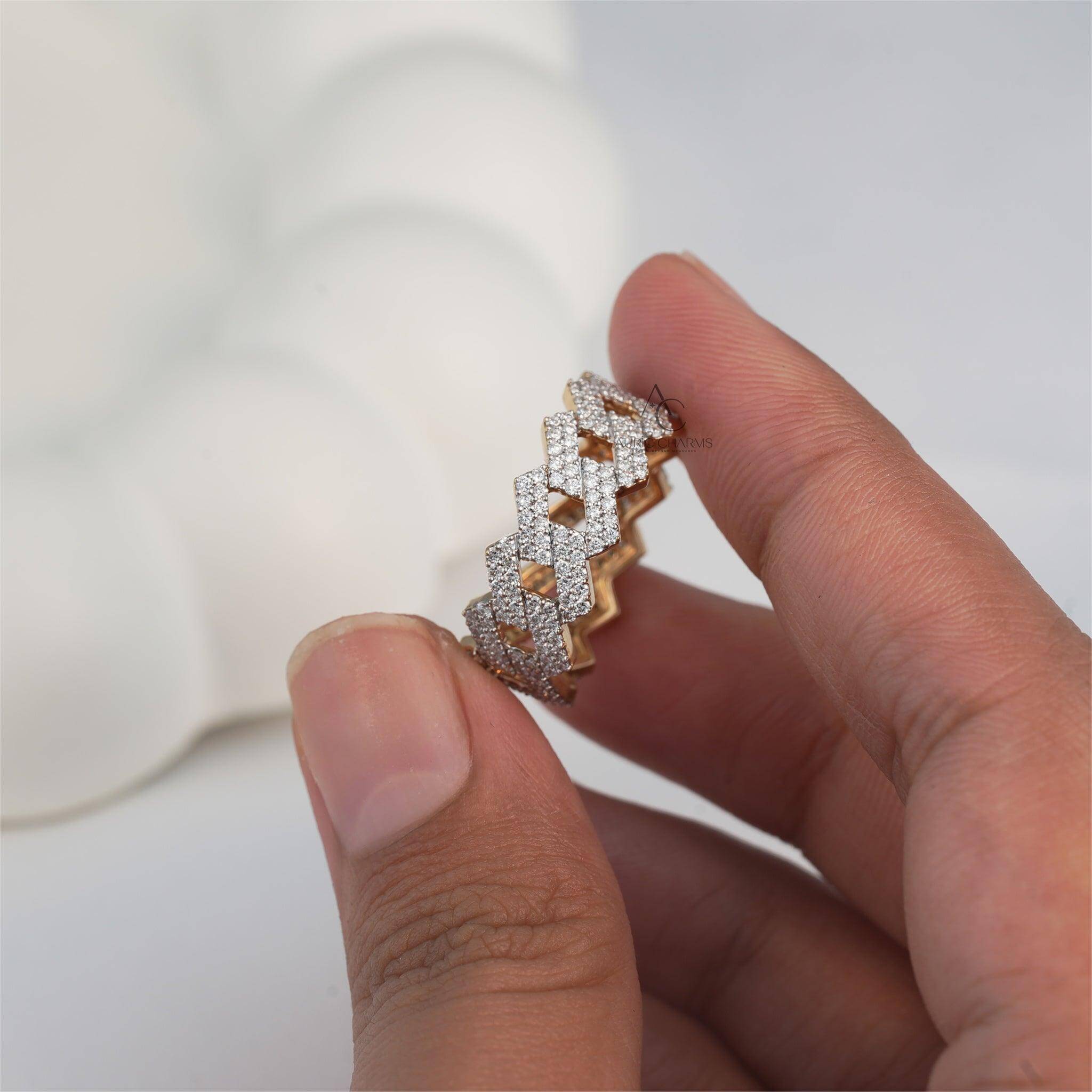 Hand displaying a gold and diamond zigzag-patterned ring with modern aesthetics.