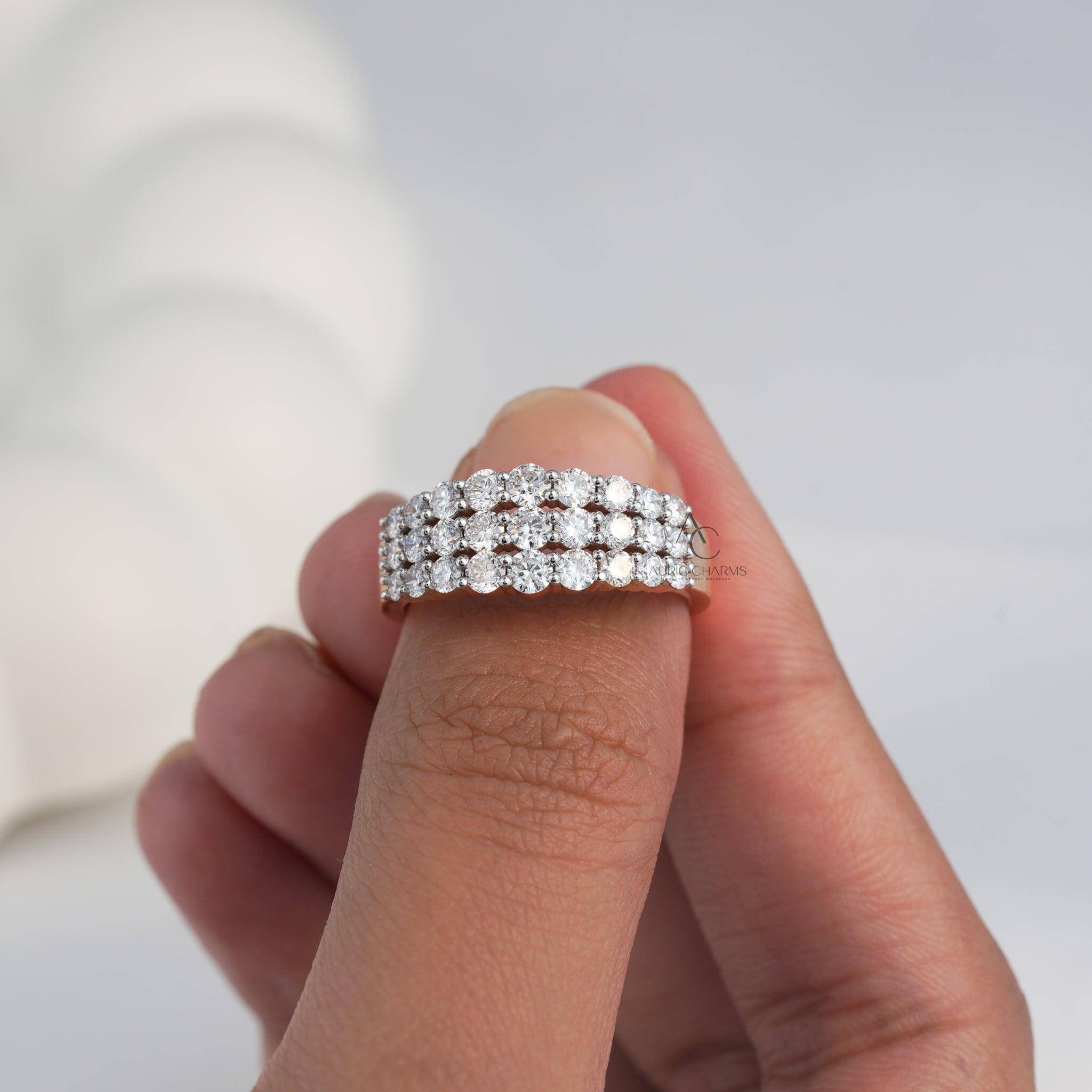 Triple-row diamond ring with lab-grown diamonds, held between fingertips.