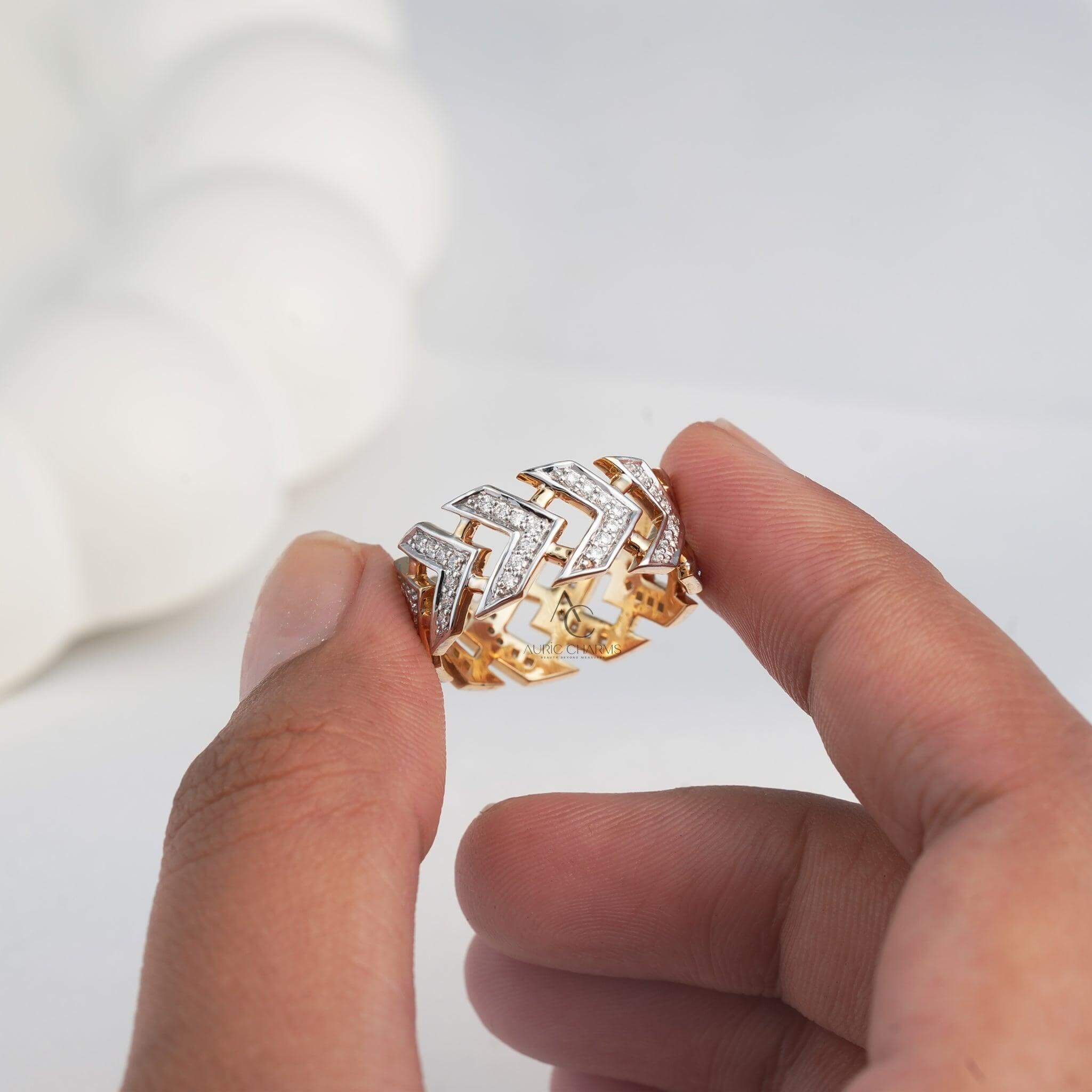 Gold chevron diamond ring held between fingers, adorned with lab-grown diamonds.