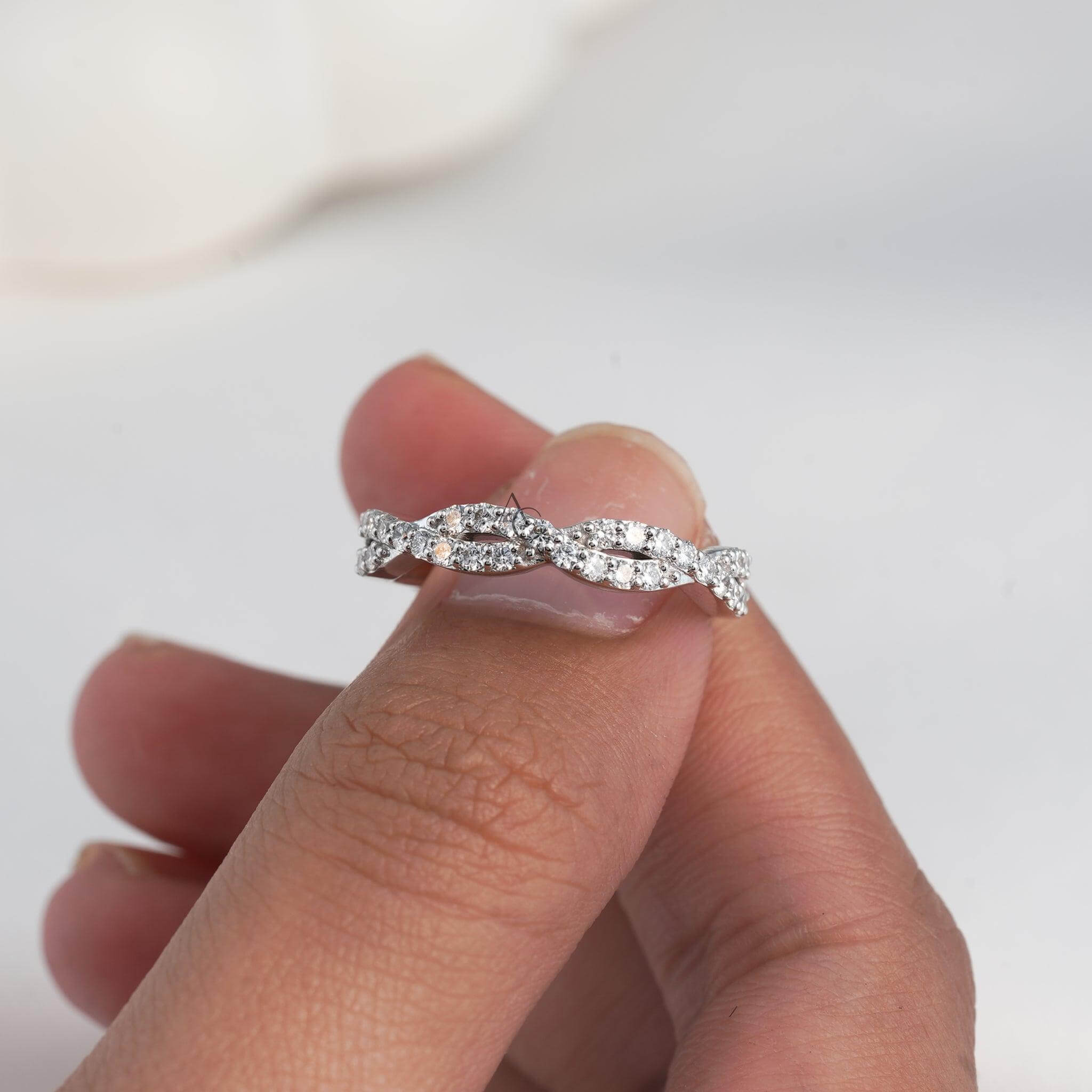 Elegant solitaire diamond ring with twisted band details held up close