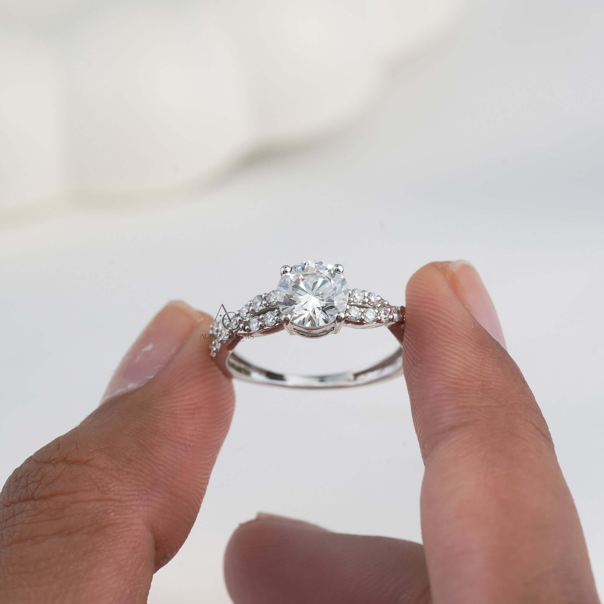 Hand holding diamond ring with intricate twisted band design.