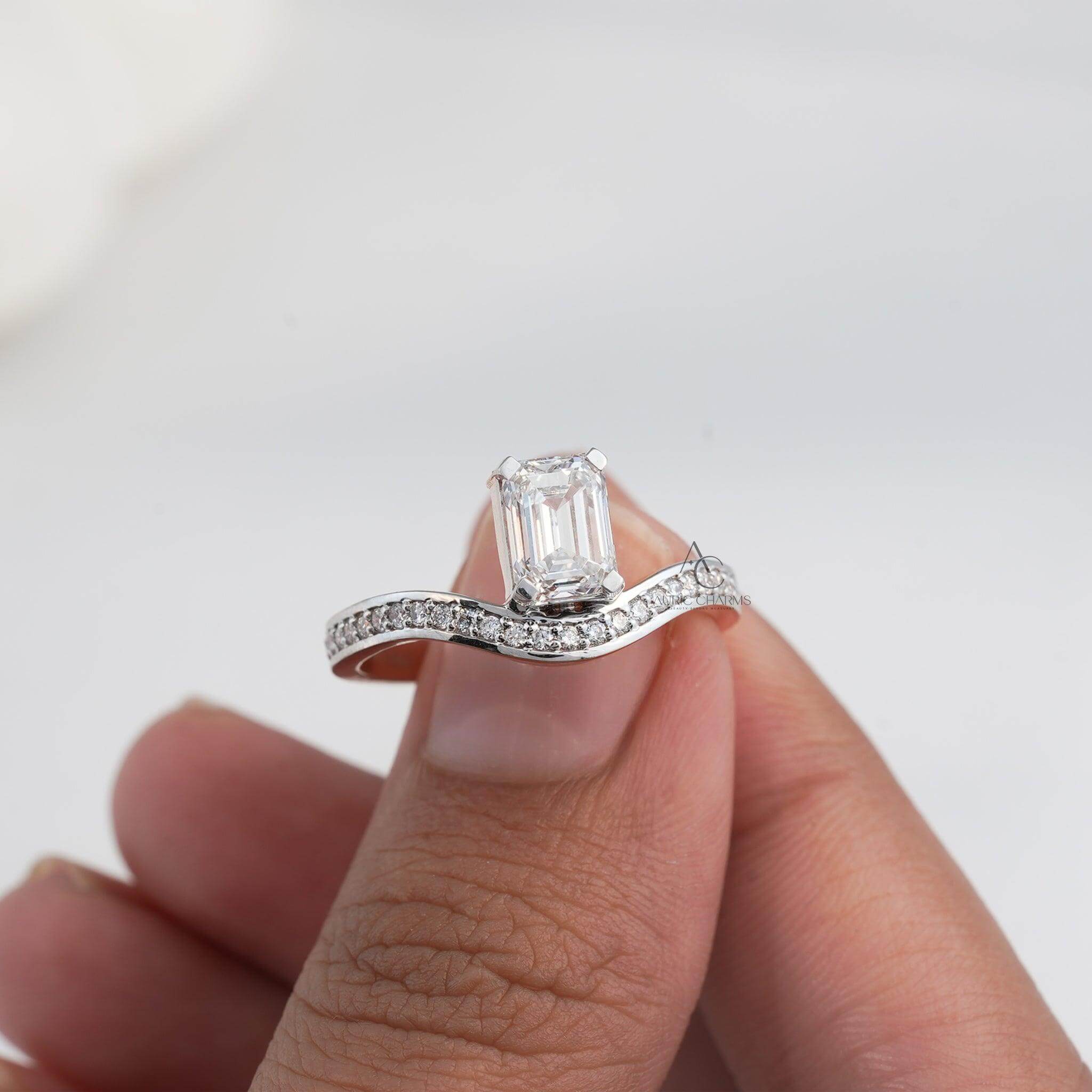lose-up of an emerald-cut diamond ring with a wavy diamond-encrusted band.