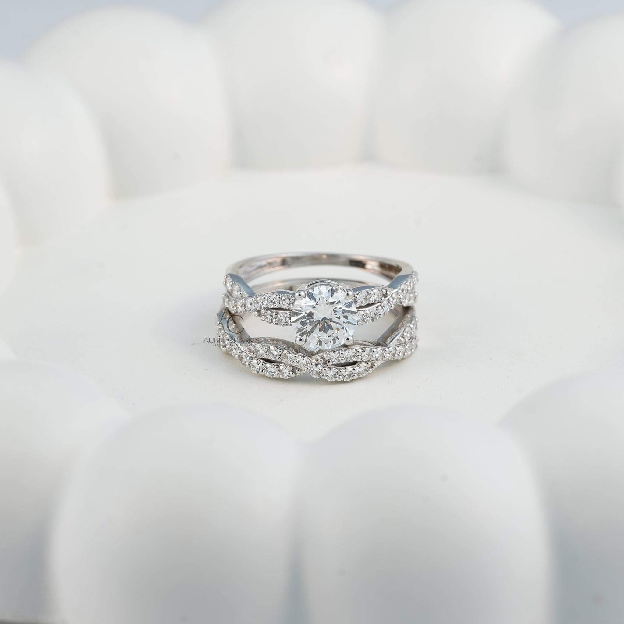 White gold engagement ring with a twisted diamond-studded band on a hand.