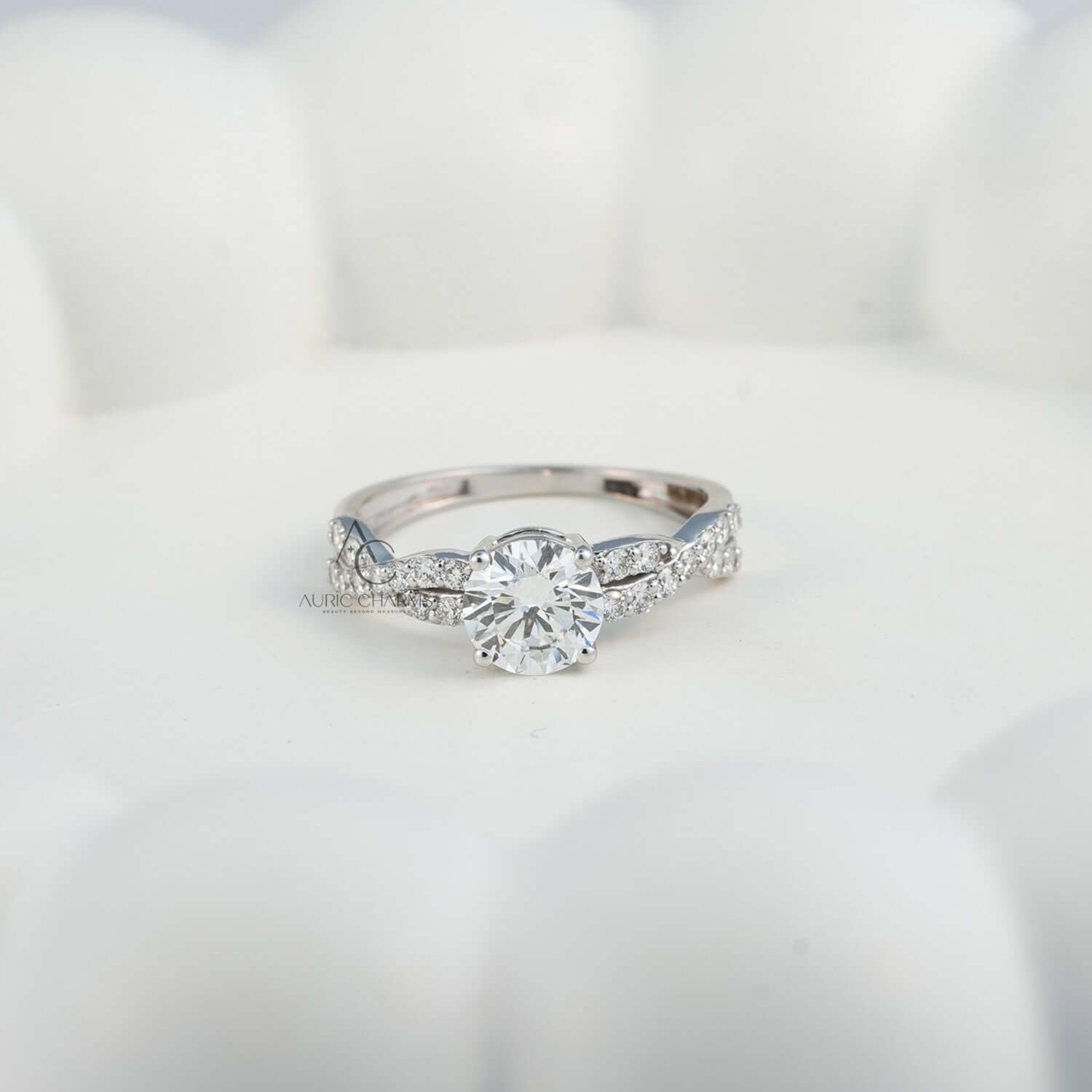 Diamond engagement ring with twisted band, placed on white decorative surface.