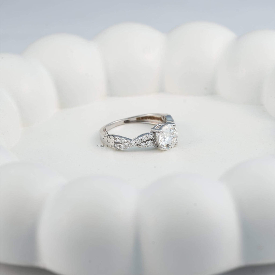 Solitaire diamond engagement ring with a twisted diamond band on a hand.