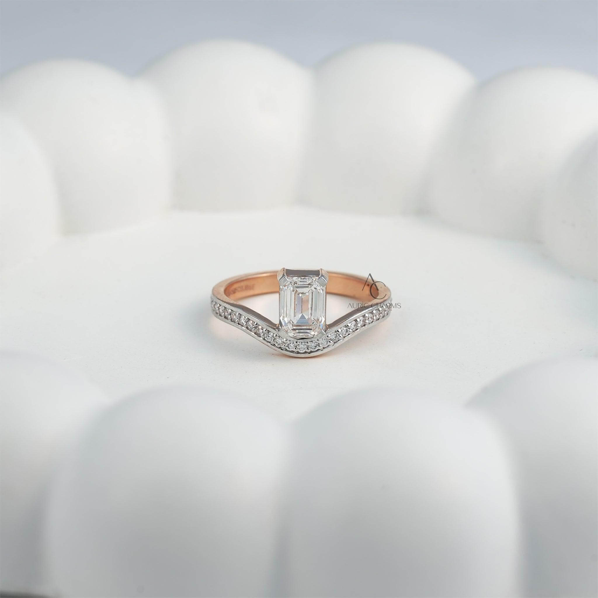 merald-cut diamond ring resting on a decorative white surface.