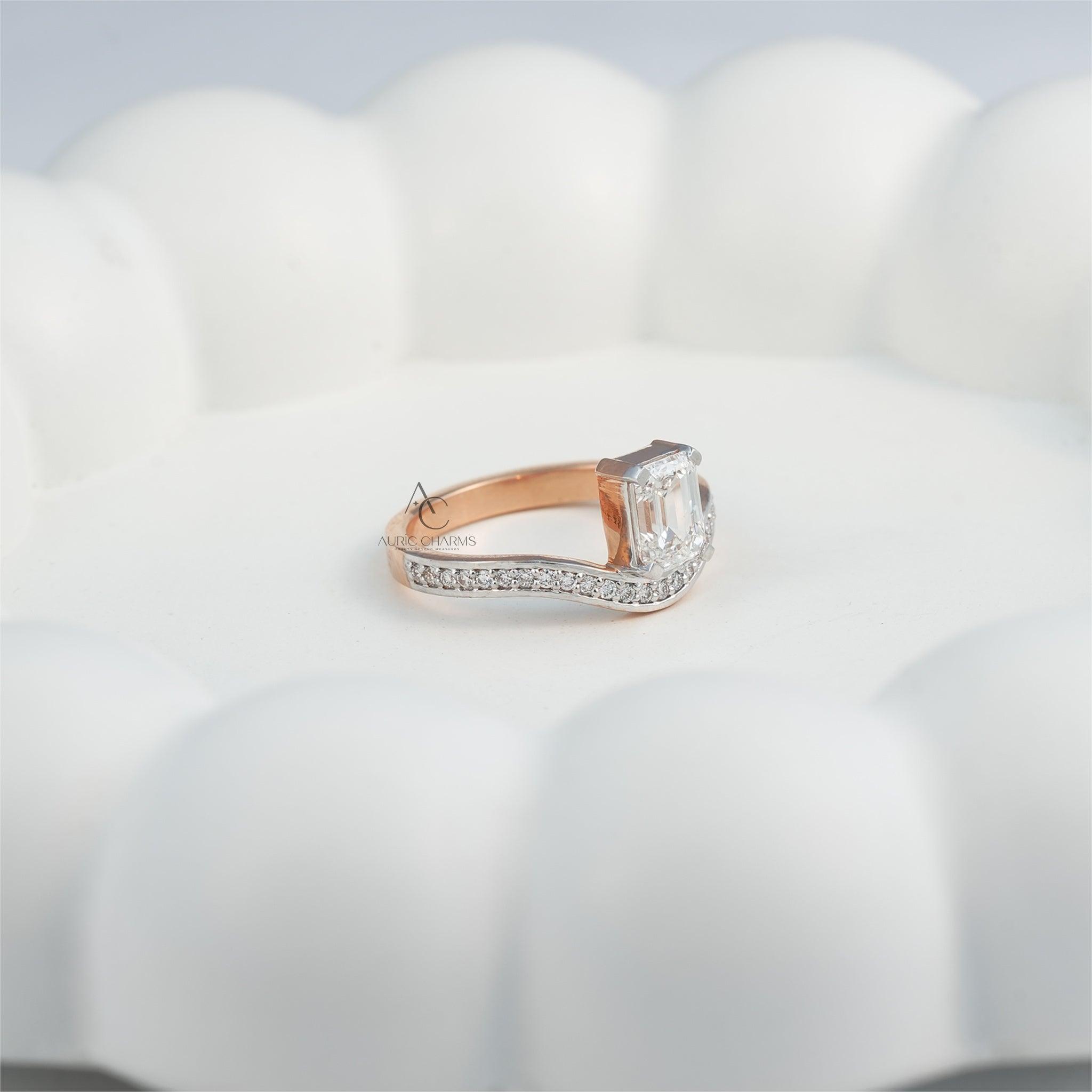 Rose gold and diamond emerald-cut ring displayed on a white decorative plate.