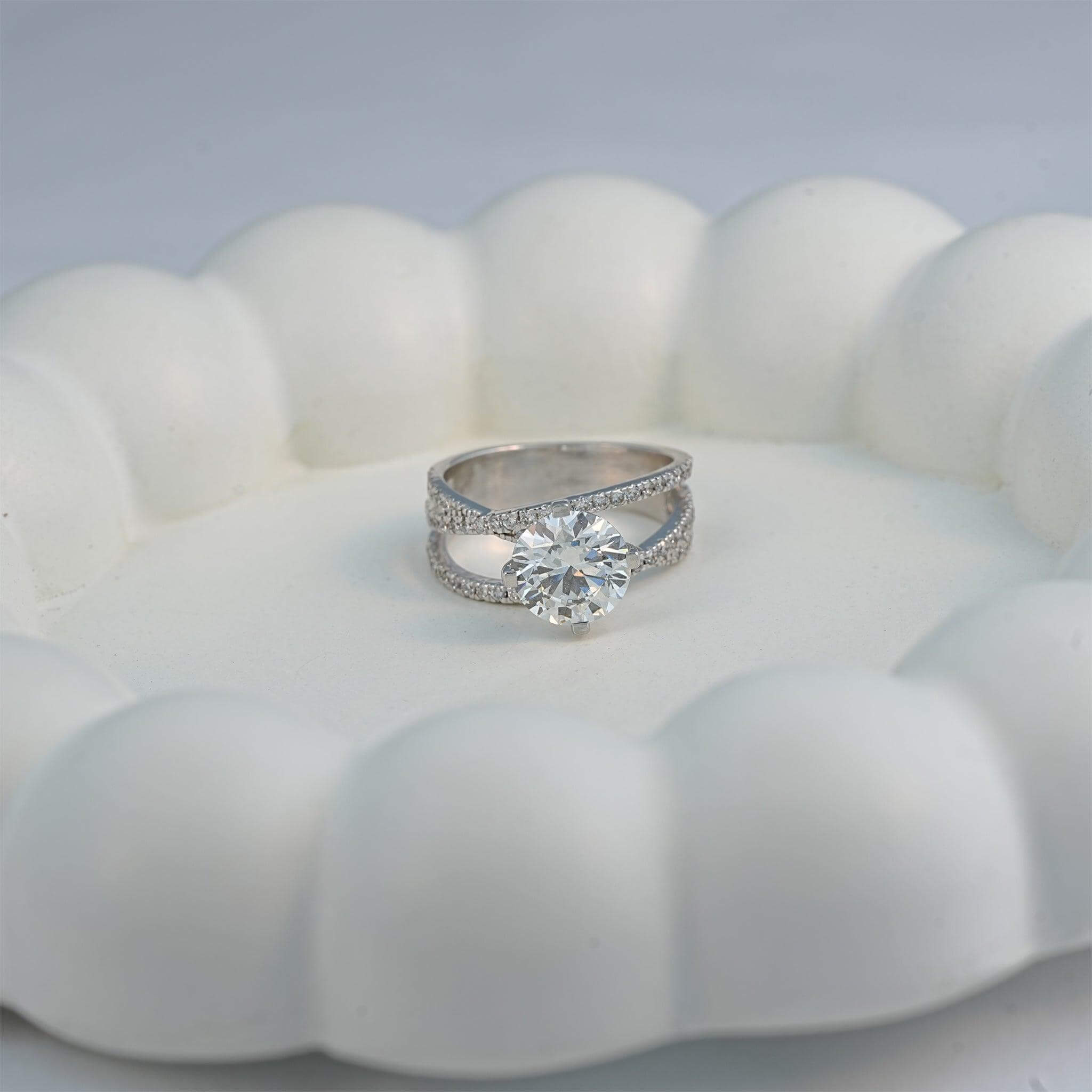 Round diamond ring displayed on a ceramic plate, showcasing a minimal and classic wedding style.