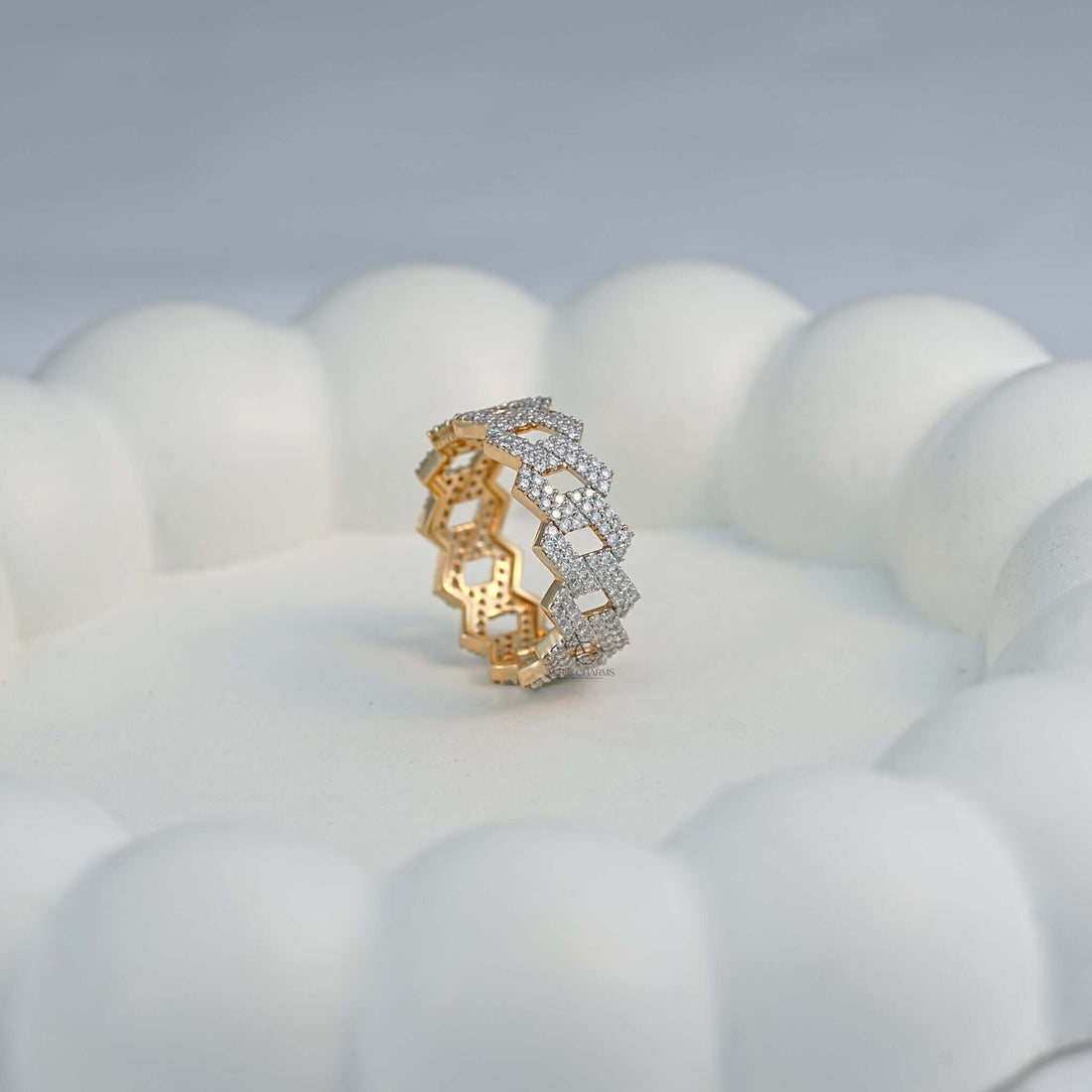 Side profile of a gold zigzag diamond band placed elegantly on a white display.