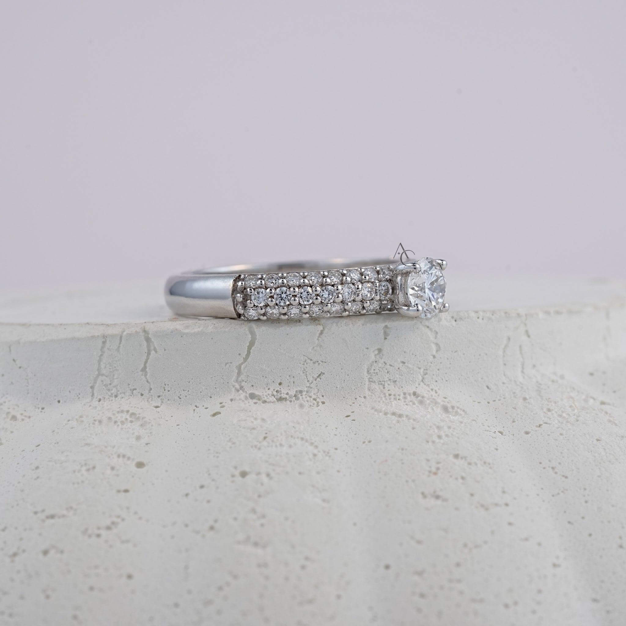 A close-up side view of a round-cut diamond ring with intricate pavé detailing, highlighting the fine craftsmanship and elegant design