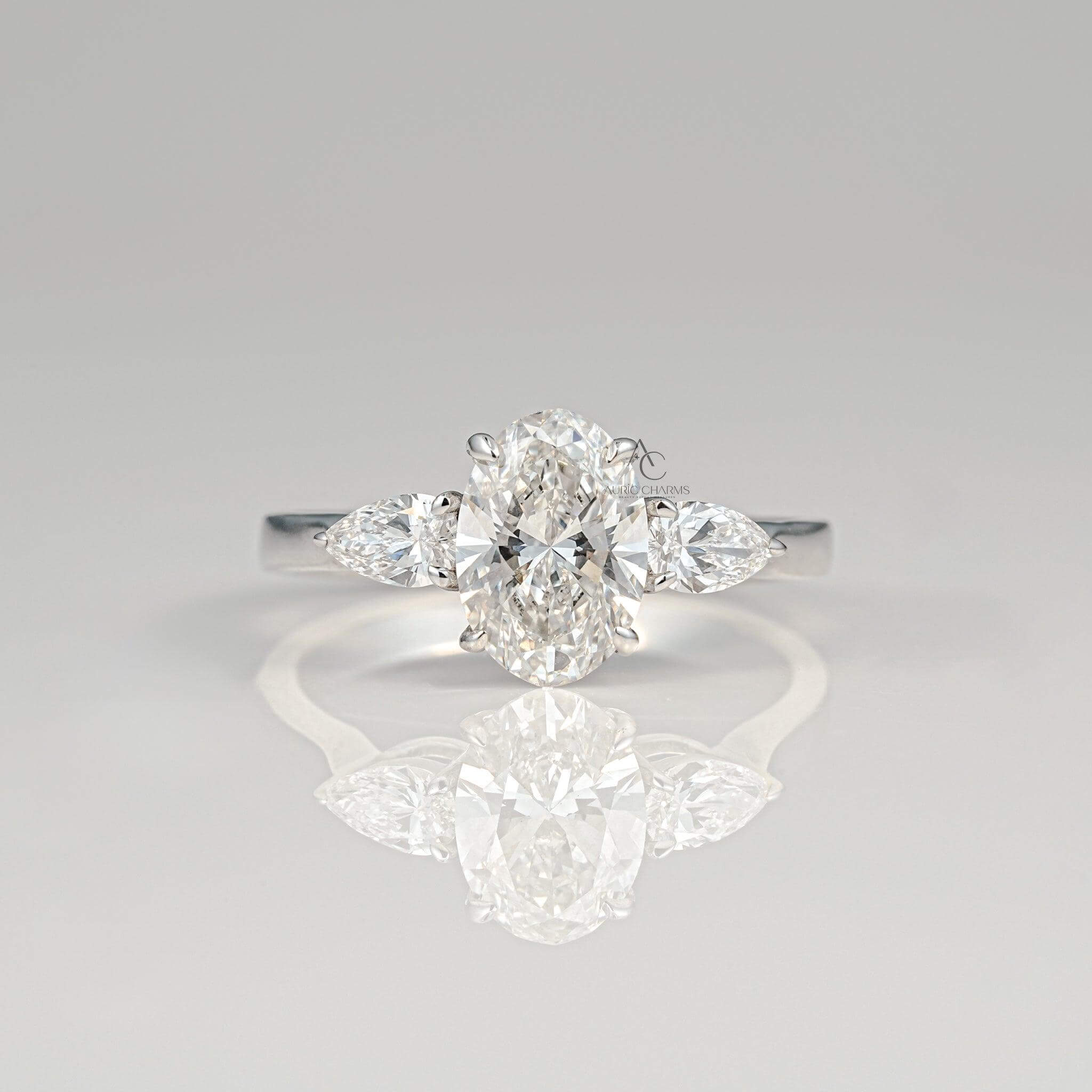 Elegant oval-cut diamond ring with pear-shaped accents on polished white gold band