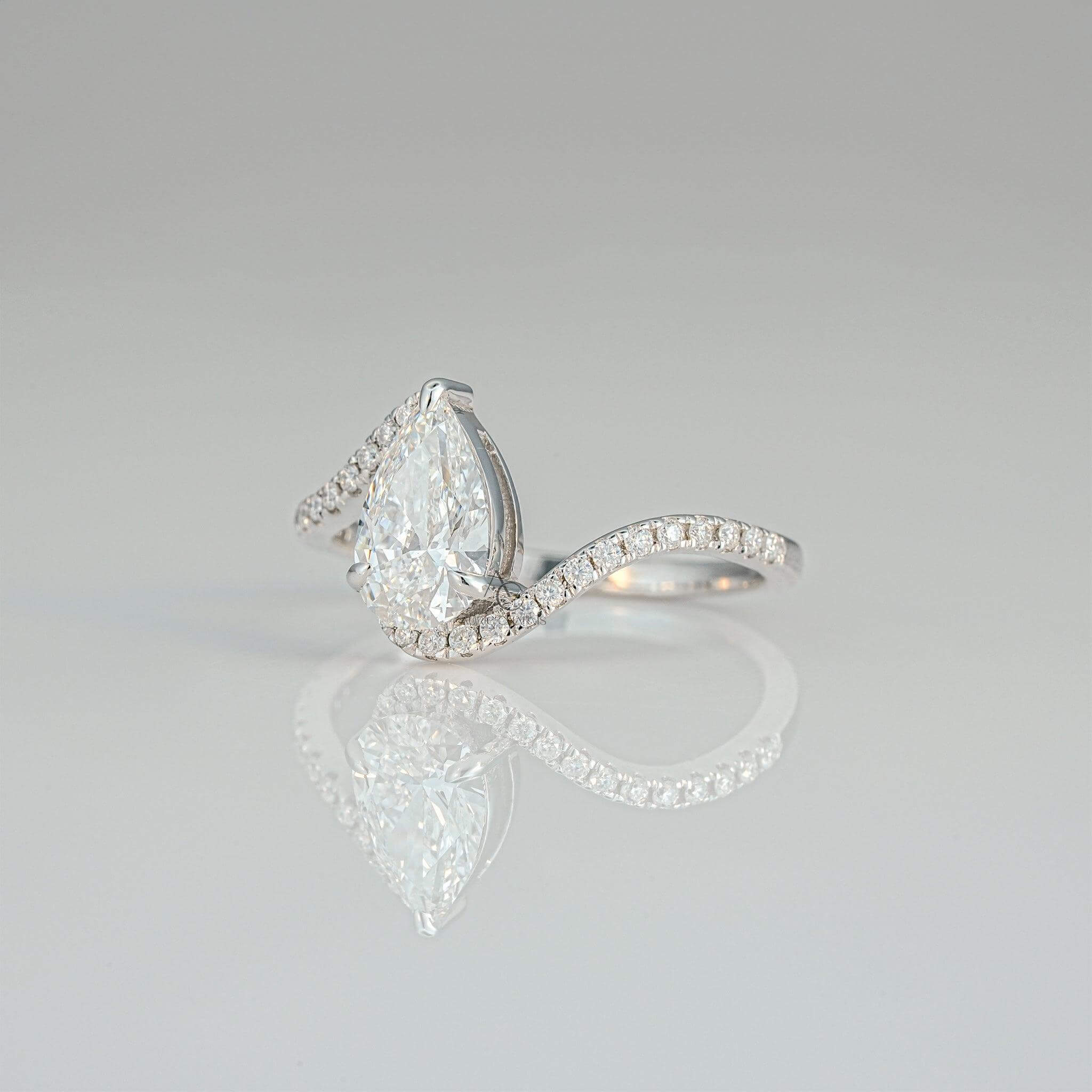 Side view of a pear-shaped diamond ring featuring a unique swirl pavé band design.
