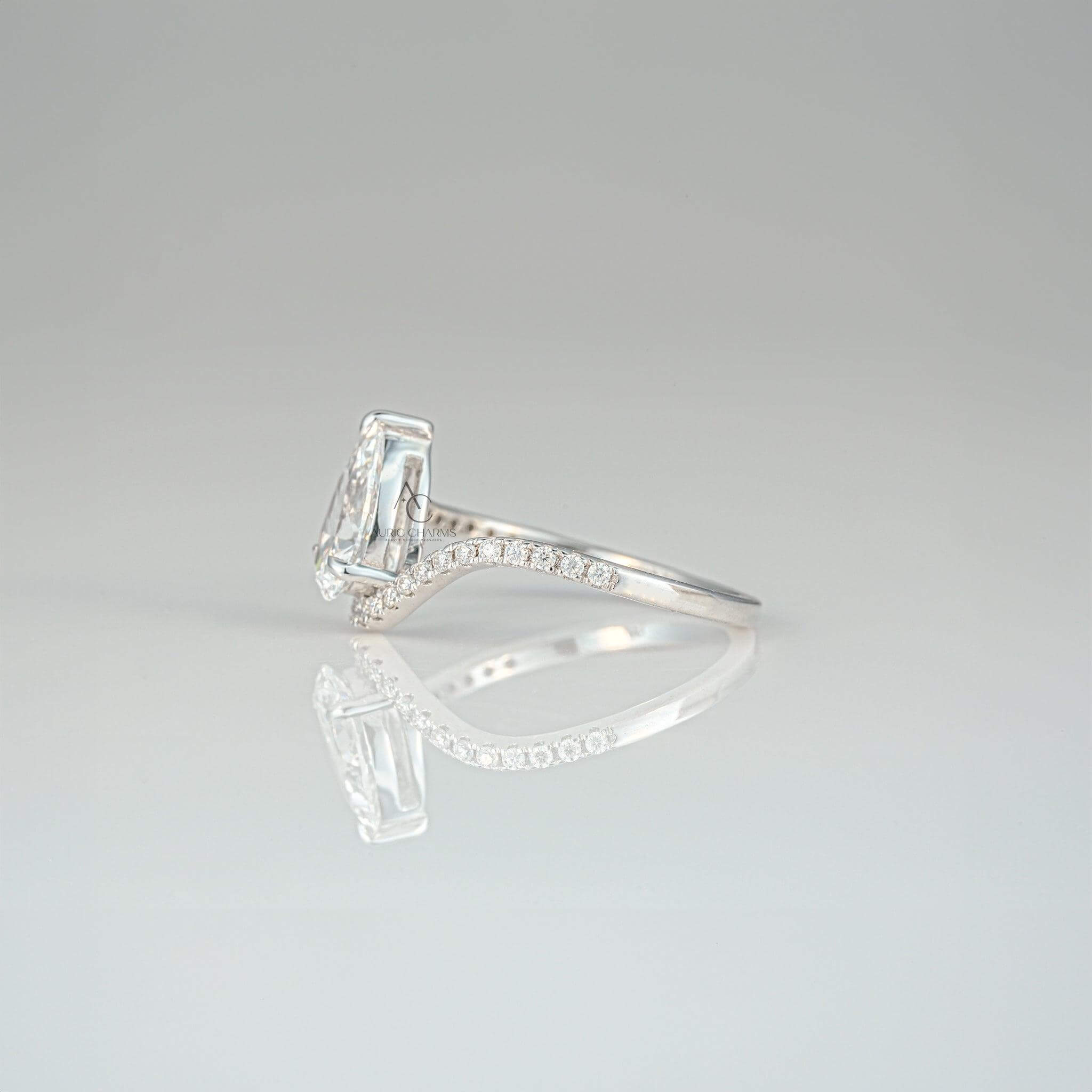 Profile of a pear-shaped diamond ring with a delicate swirl and prong setting.