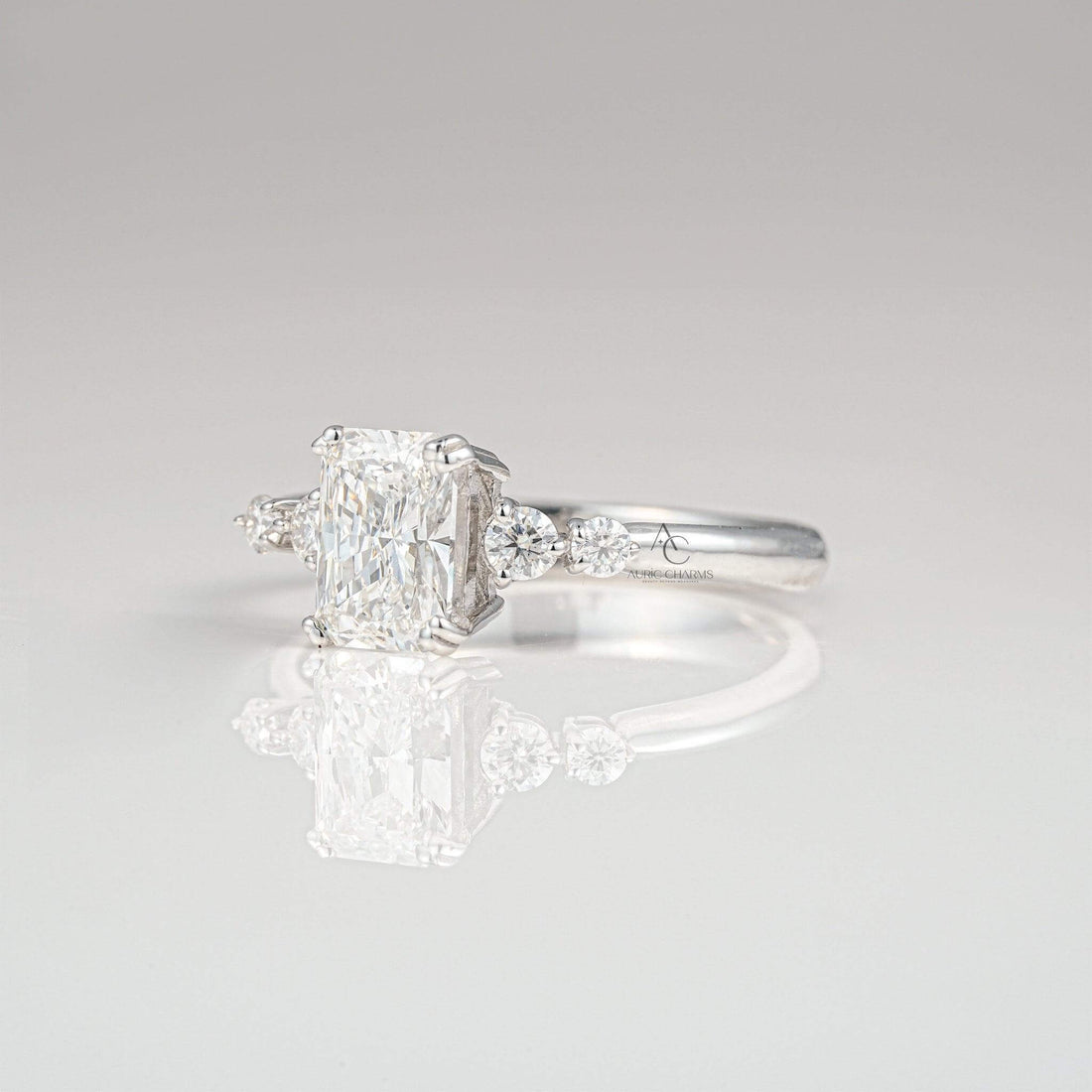 Elegant radiant-cut diamond ring with sparkling side stones, set in white gold.