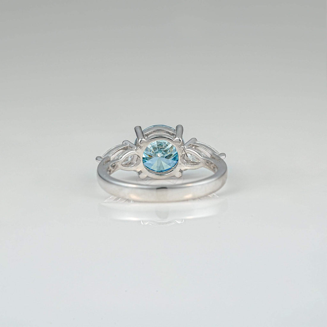 Back view of a blue diamond three-stone ring, showcasing intricate detailing and pear-shaped accents.