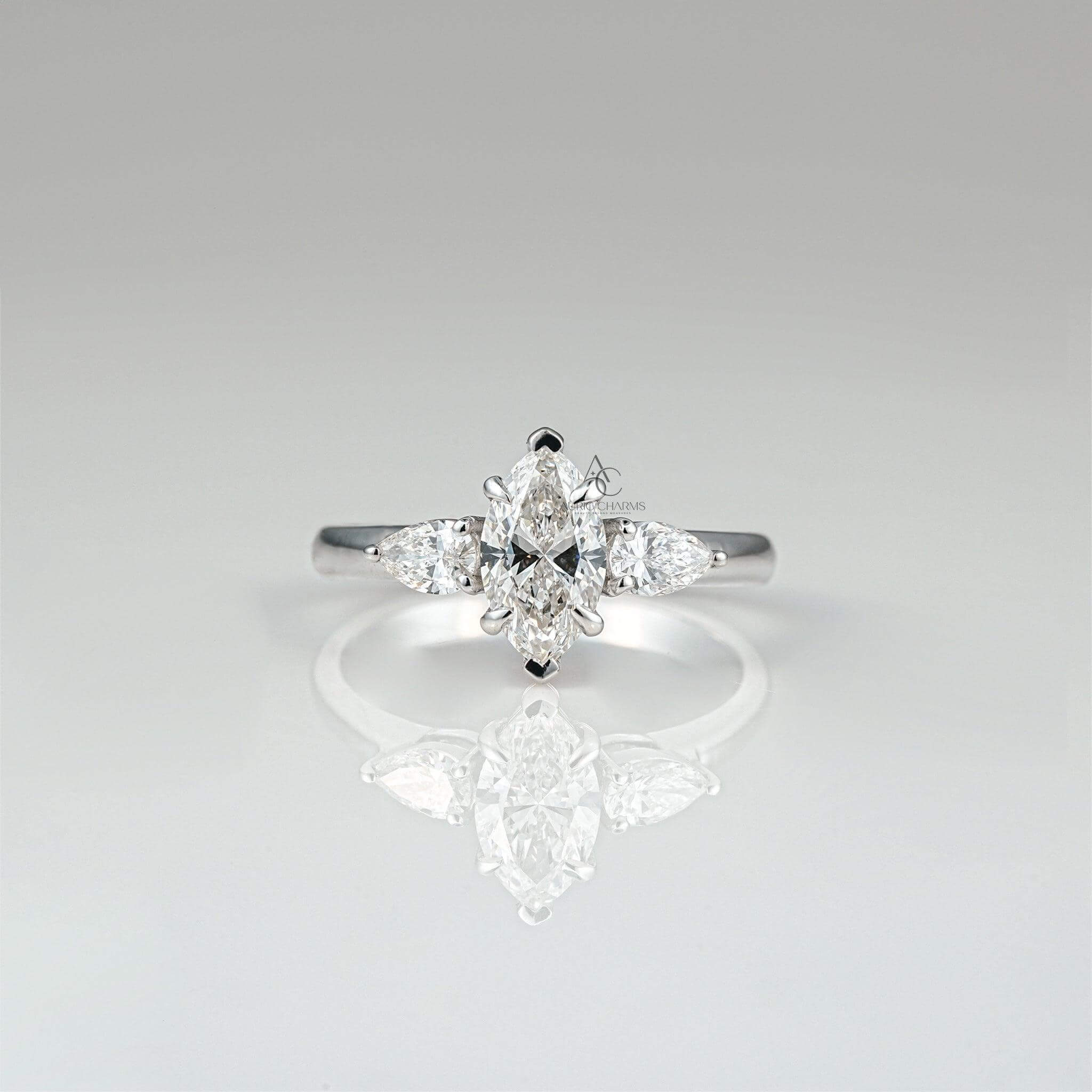 Marquise-cut diamond ring with pear accents on reflective surface, elegant solitaire design.