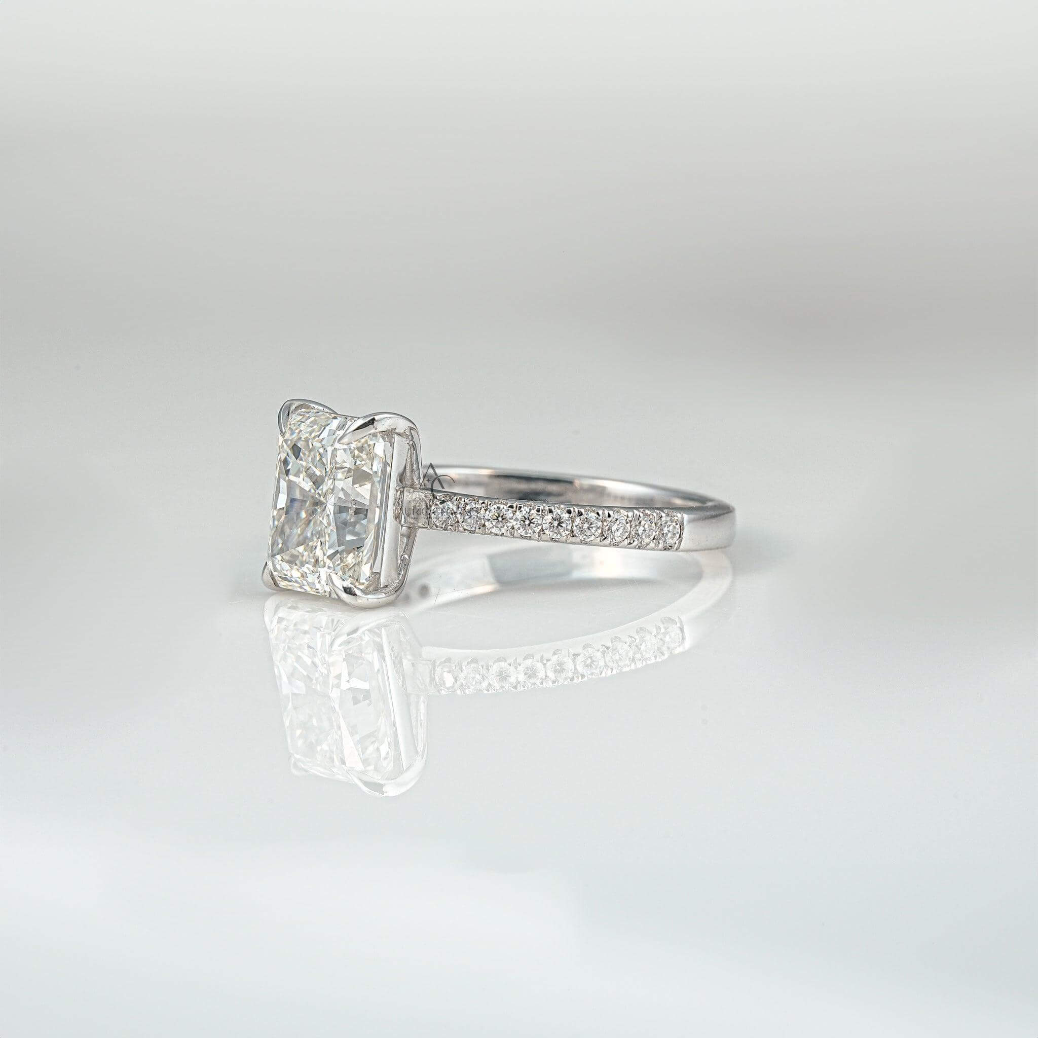 Side view of a radiant-cut diamond ring featuring a diamond-studded band.