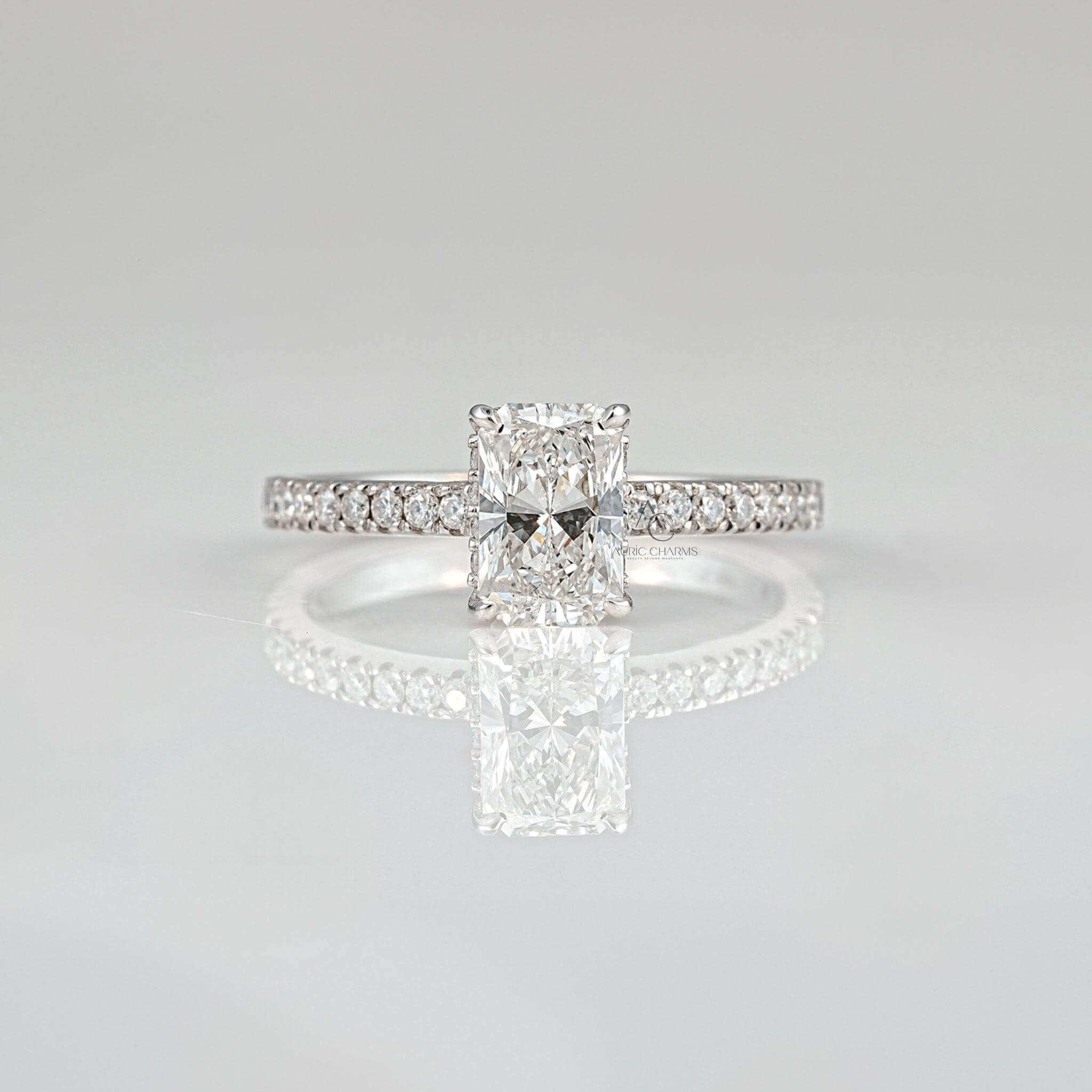 Radiant-cut diamond engagement ring with pavé band reflecting brilliance on a sleek surface.