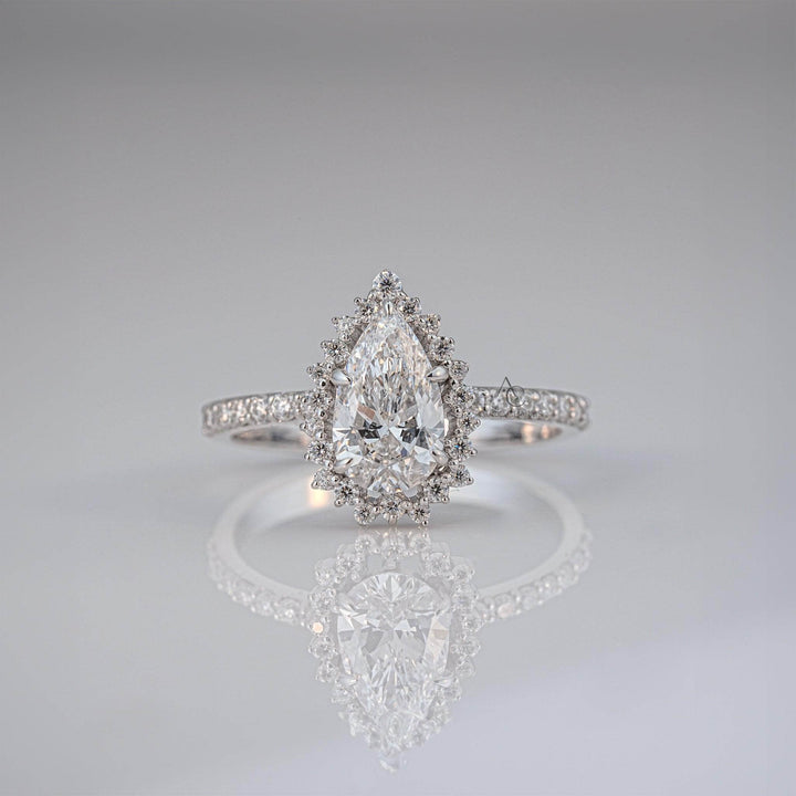 Pear-shaped halo lab-grown diamond engagement ring with pave band reflecting its brilliance.