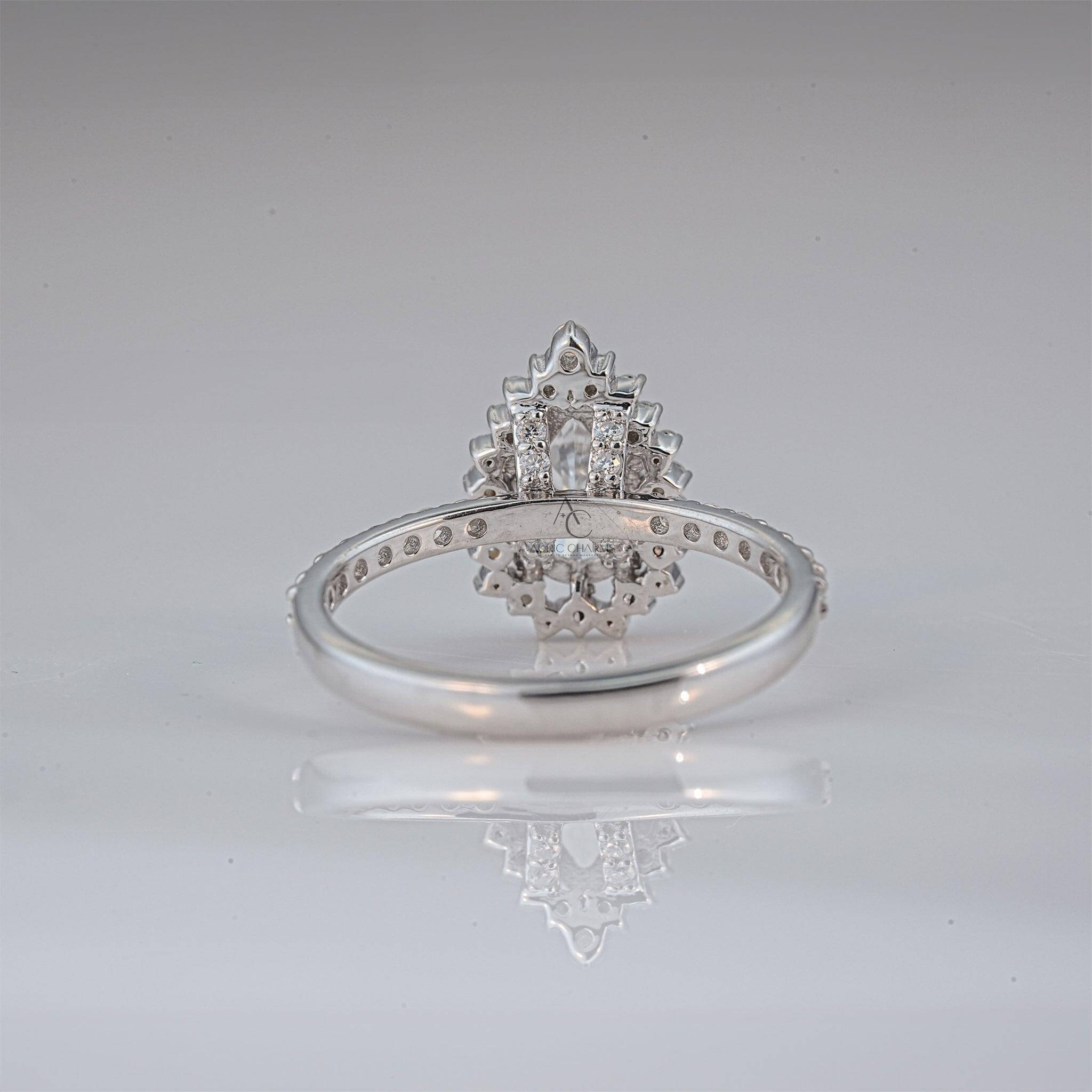Close-up of pear-shaped lab-grown diamond ring on finger, highlighting its dazzling halo setting.