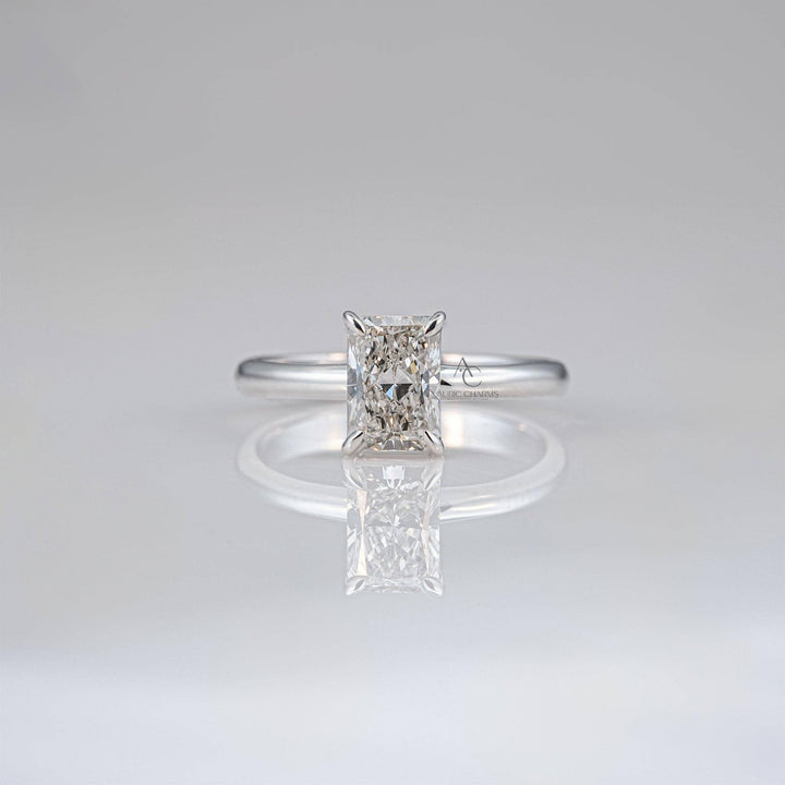 Radiant-cut diamond solitaire ring on sleek white gold band for timeless elegance.