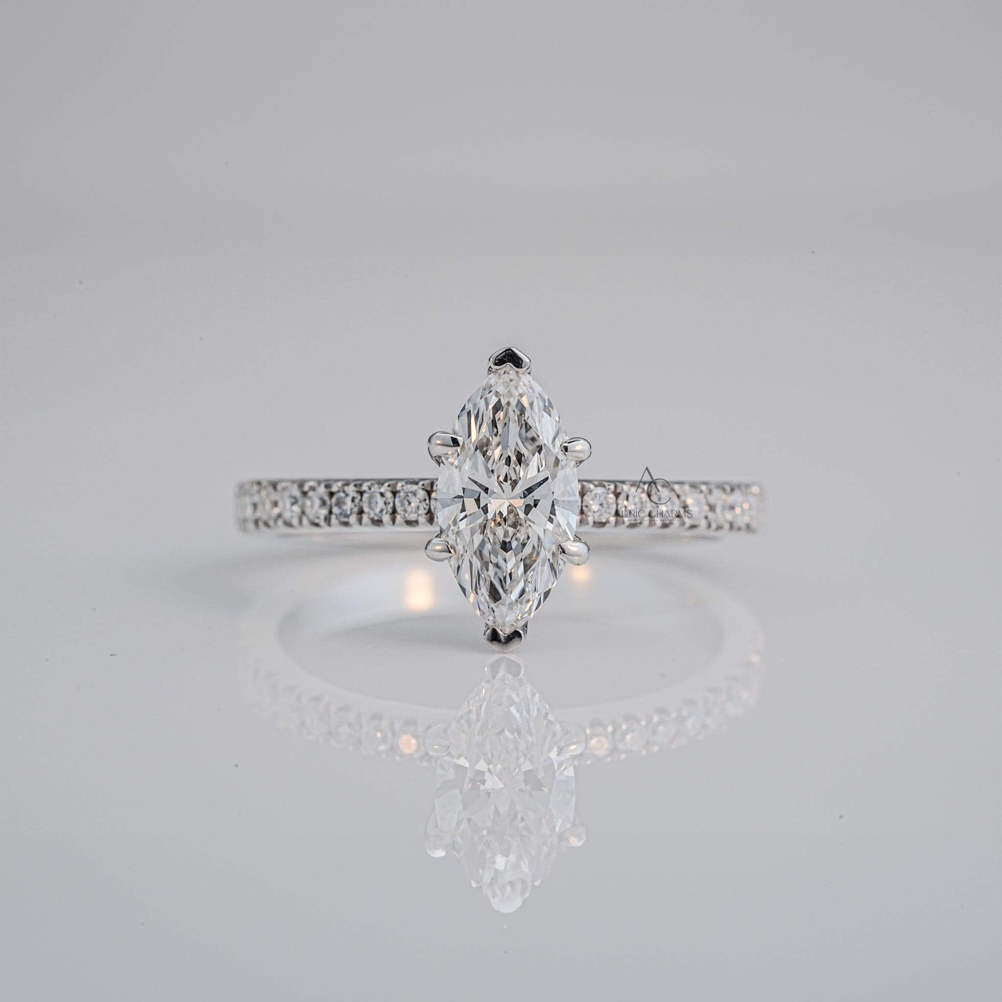 A marquise-cut diamond engagement ring on a platinum band with pavé-set diamonds, elegantly reflecting light.